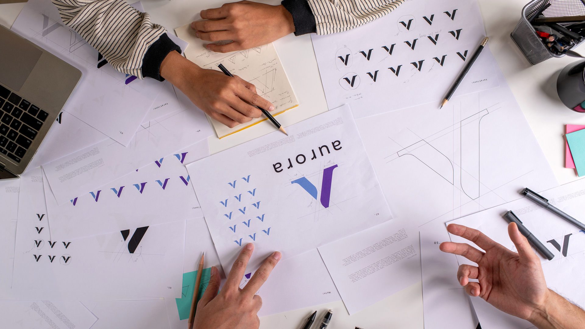 people looking at logo sketches