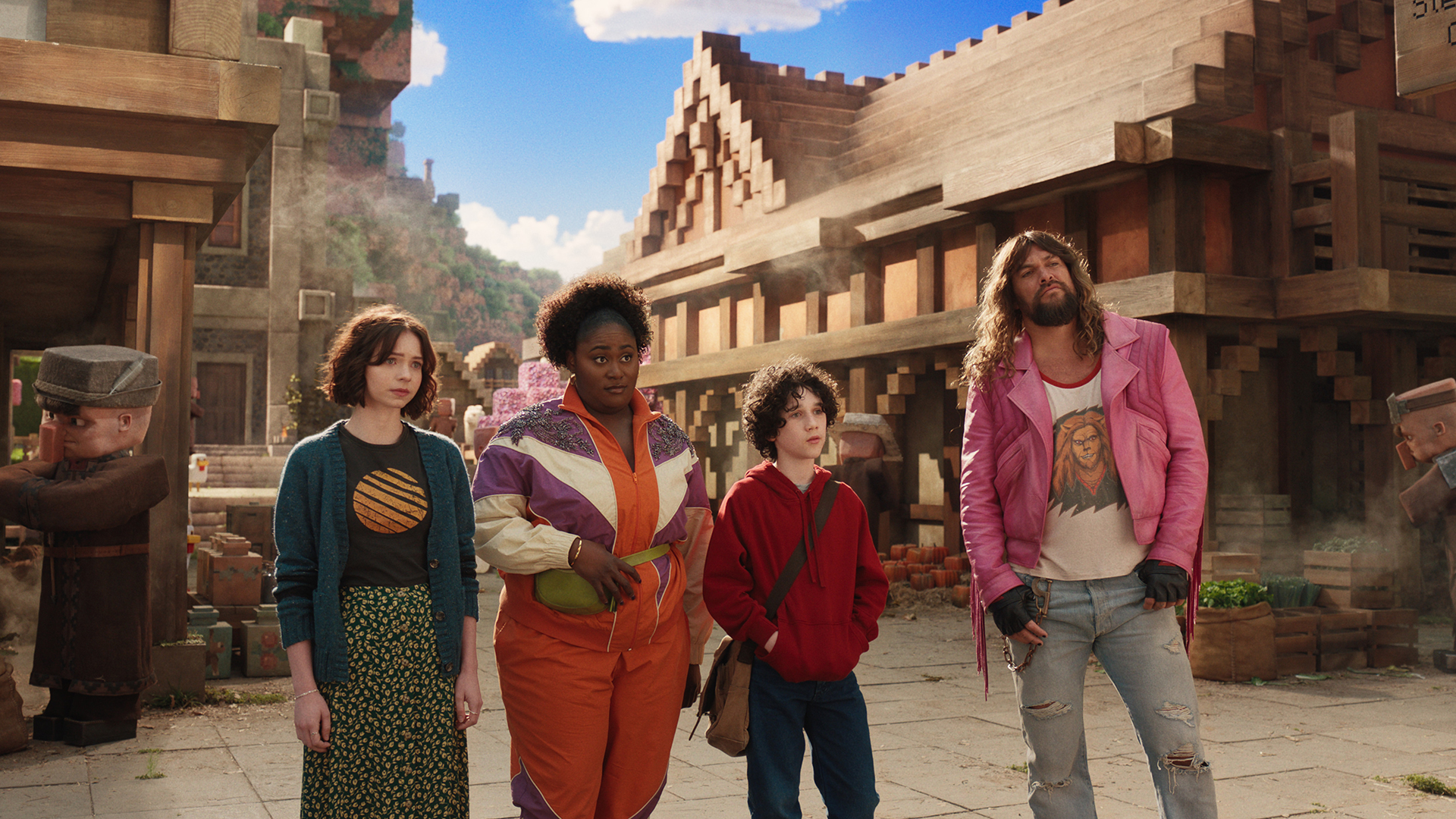 Natalie, Dawn, Henry, and Garrett standing in an Overworld village in A Minecraft Movie