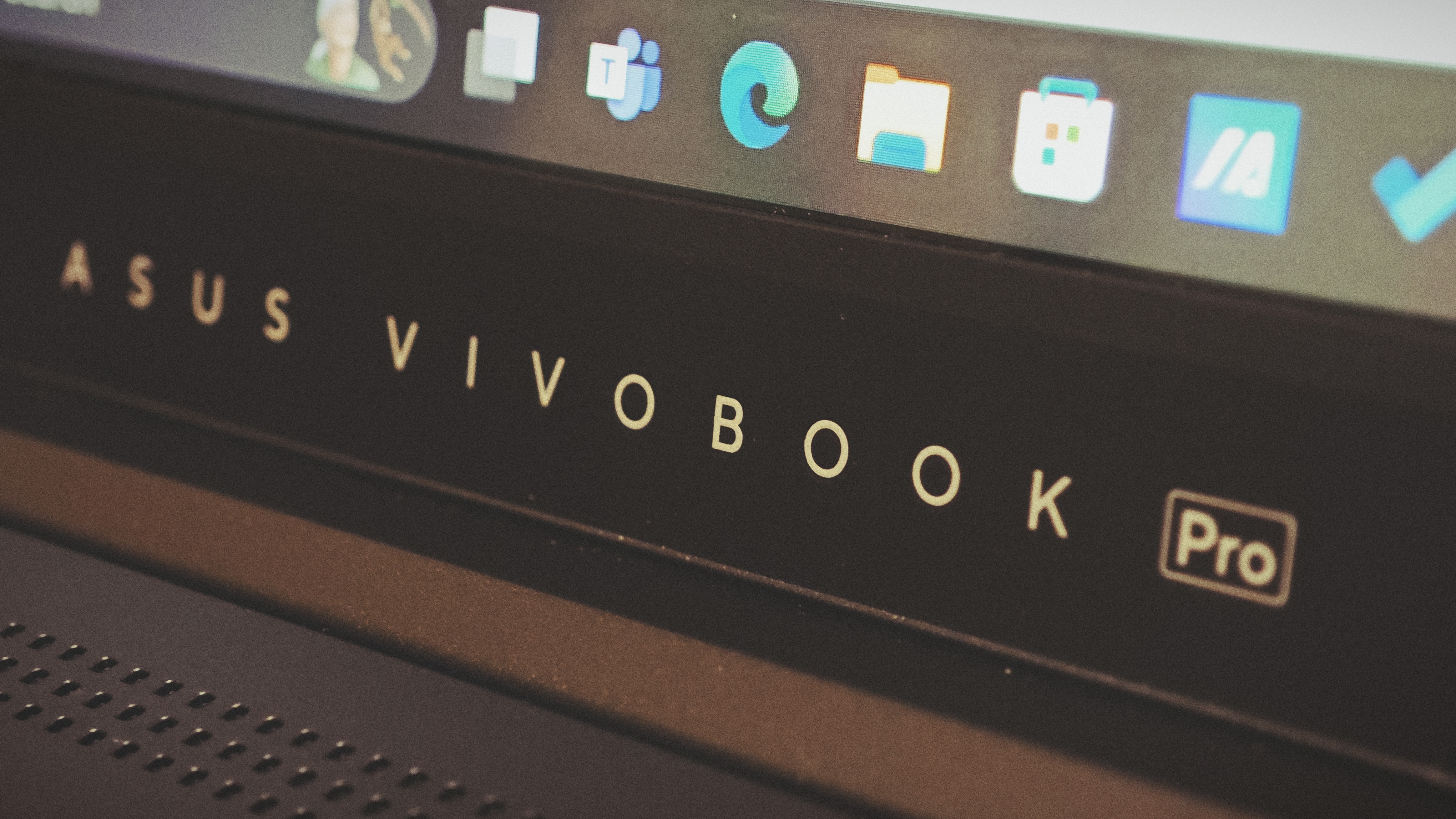 An Early Grey ASUS Vivobook Pro 15 OLED (2024) sitting on a wooden floor