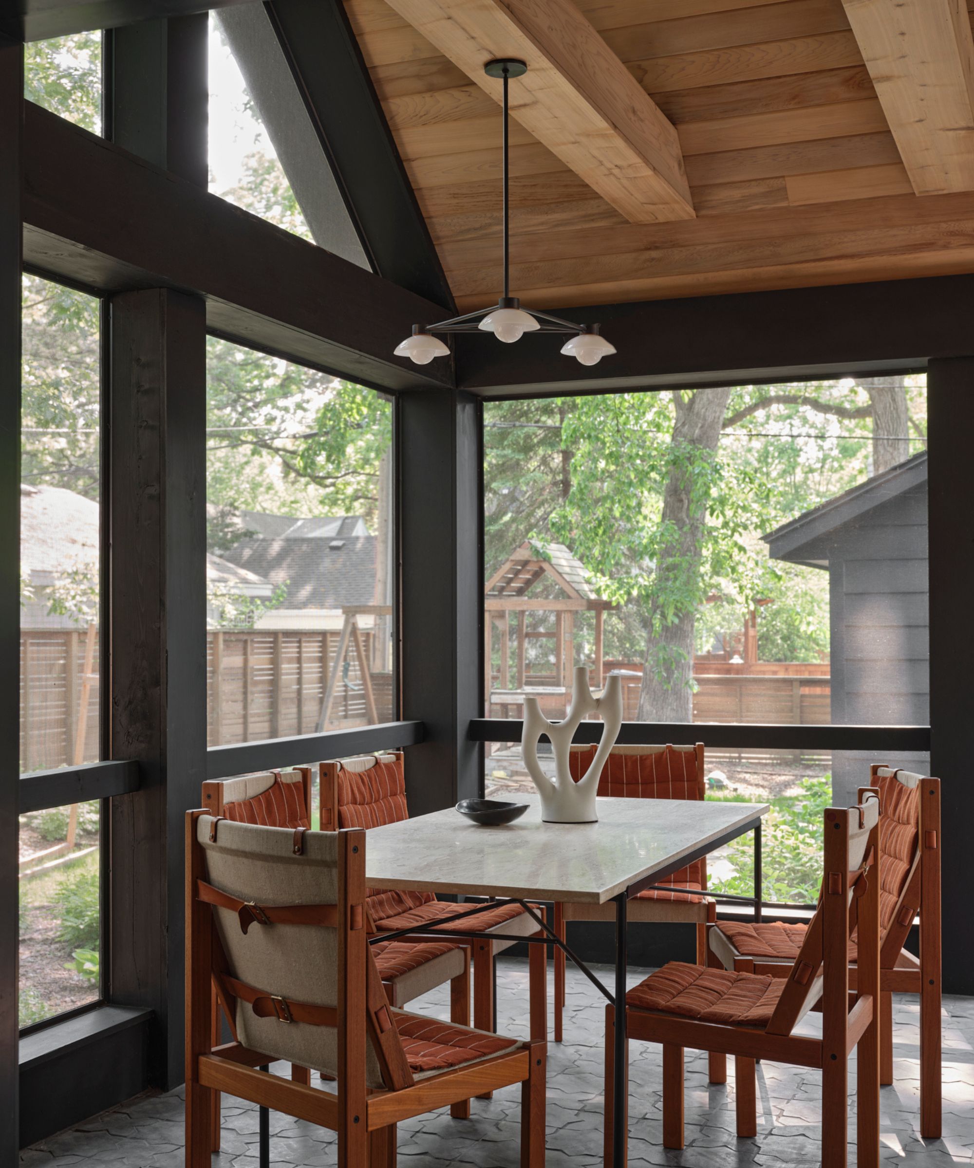 sunroom dining room with vintage furniture and a wooden paneled ceiling