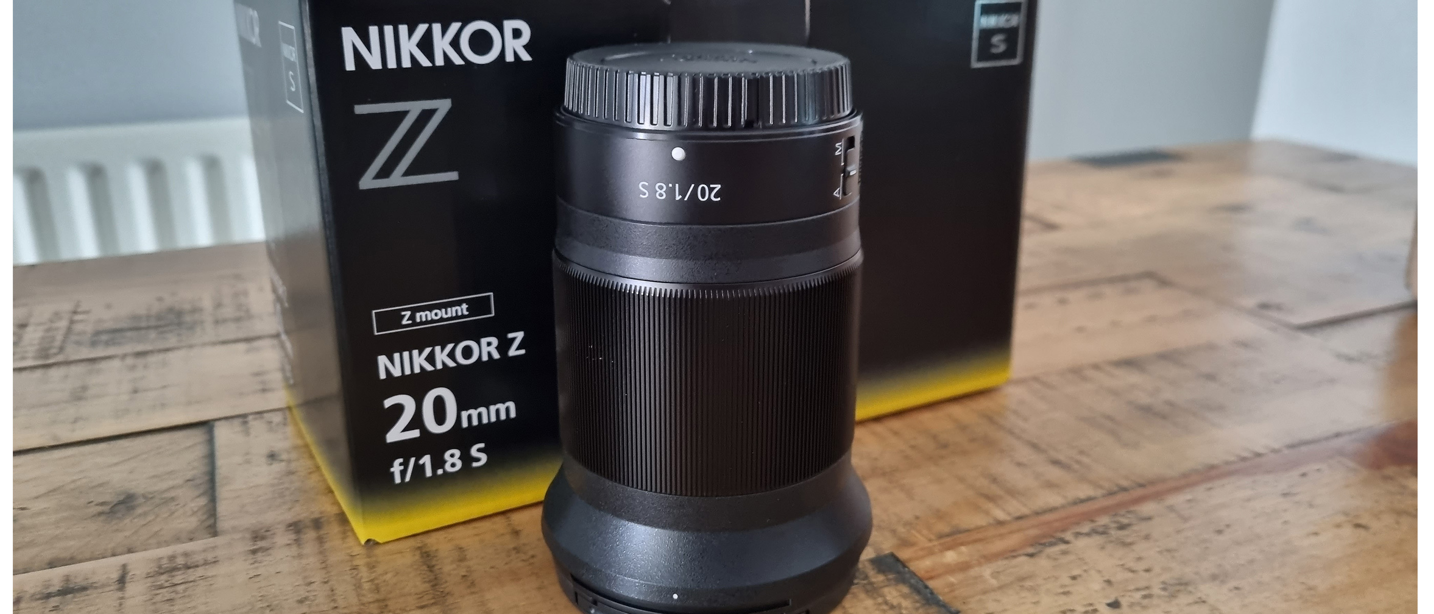 Shot of the Nikon Z 20mm f/1.8 next to its box