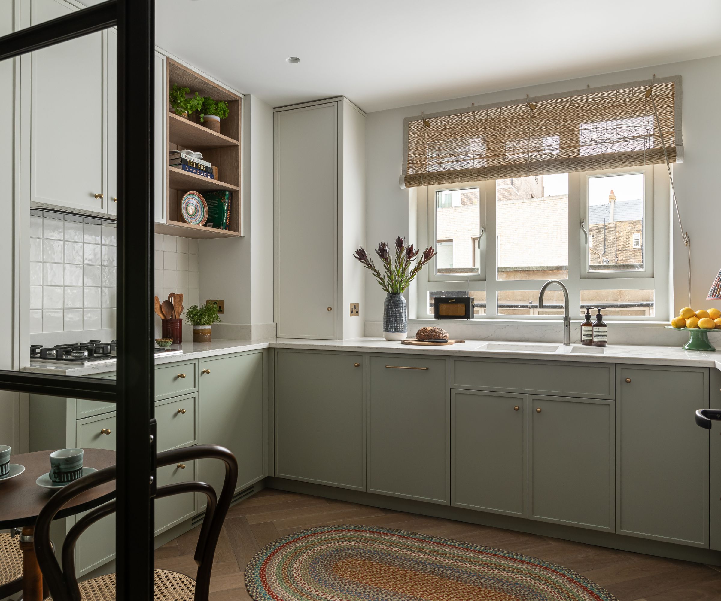 a white and pale green micro shaker kitchen with wood shelves and a white countertop