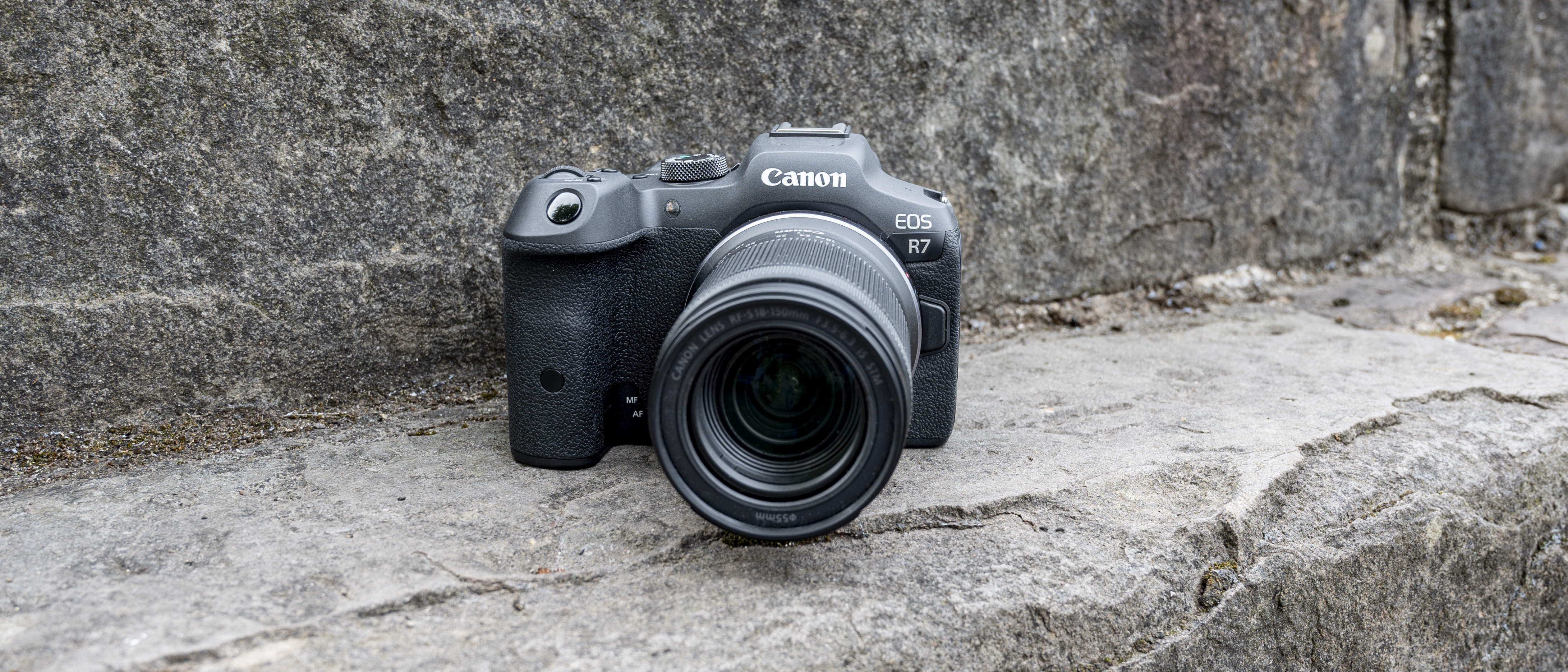 The Canon EOS R7 camera sitting on a stone step