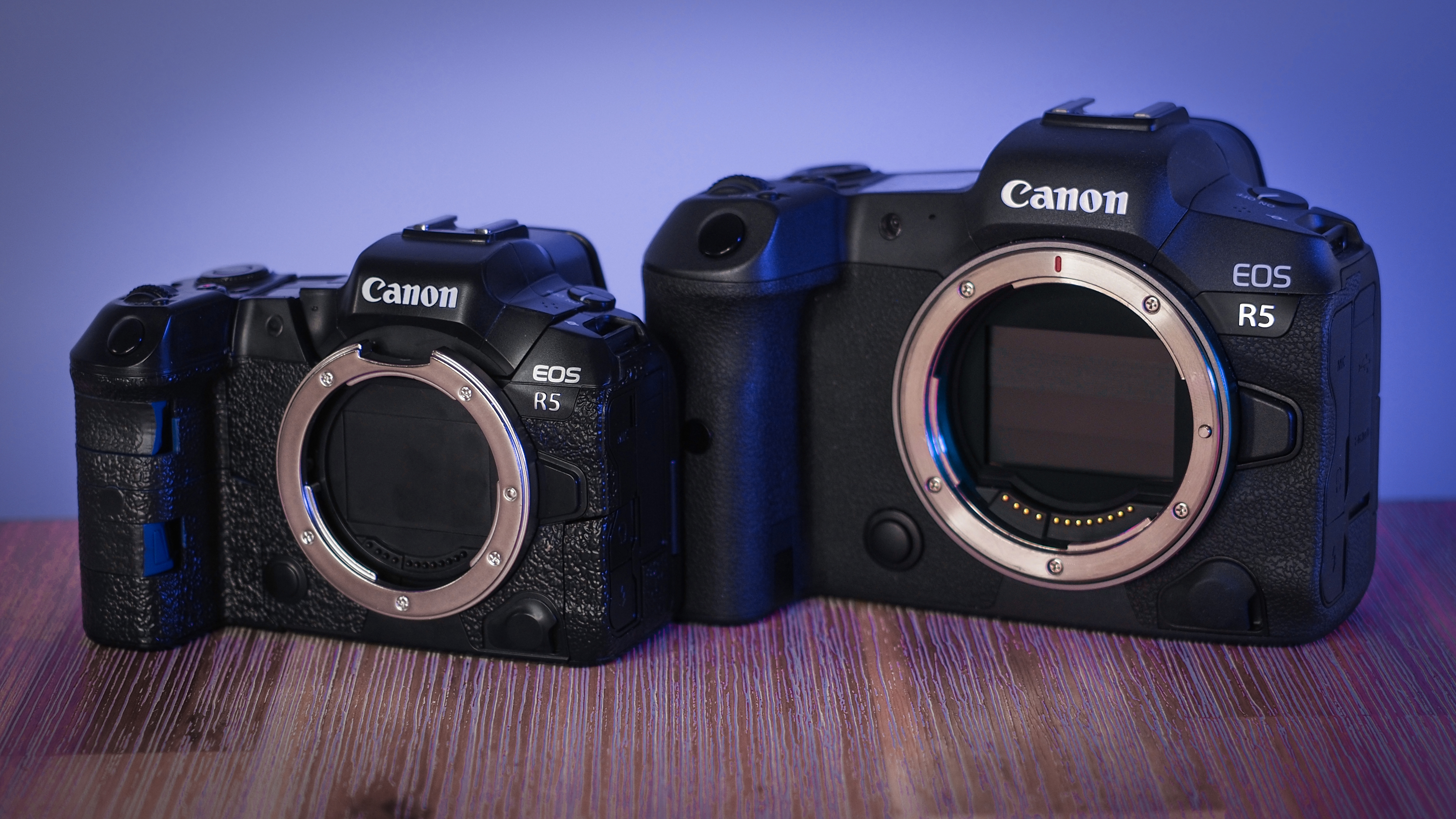 A &quot;baby&quot; Canon EOS R5 next to a full-size Canon EOS R5, on a wooden surface