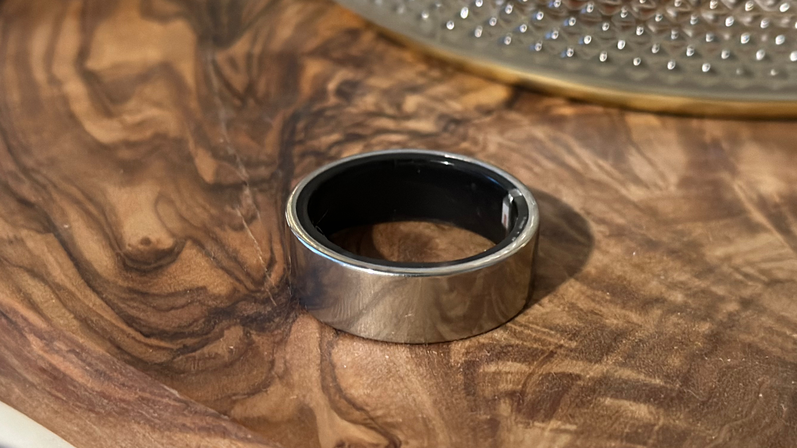 The Ultrahuman Ring Air sitting on top of a wooden table.