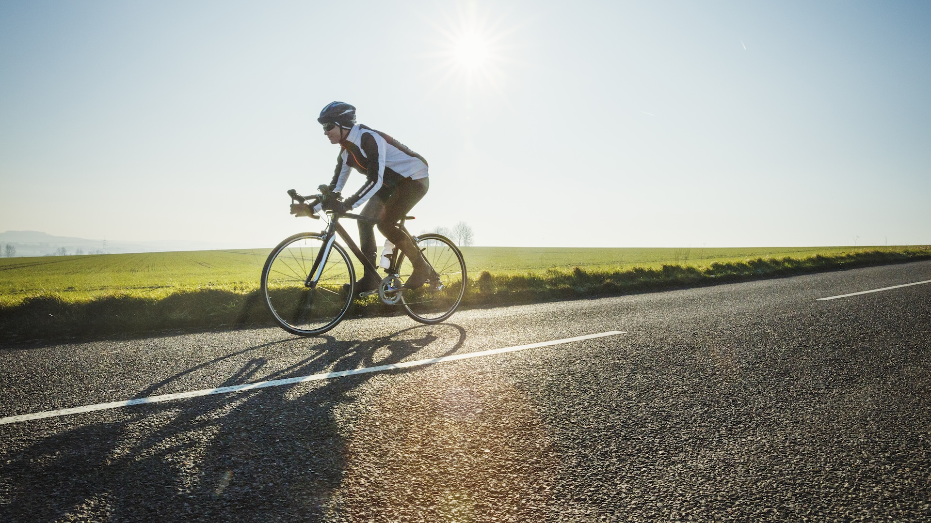 A man cycling on a flat road
