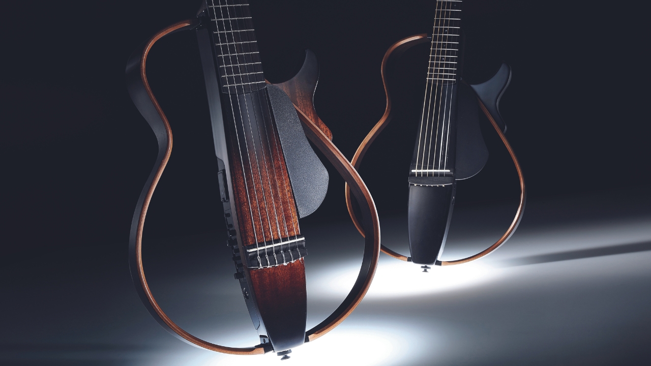 Two Yamaha Silent Guitars on a dark background
