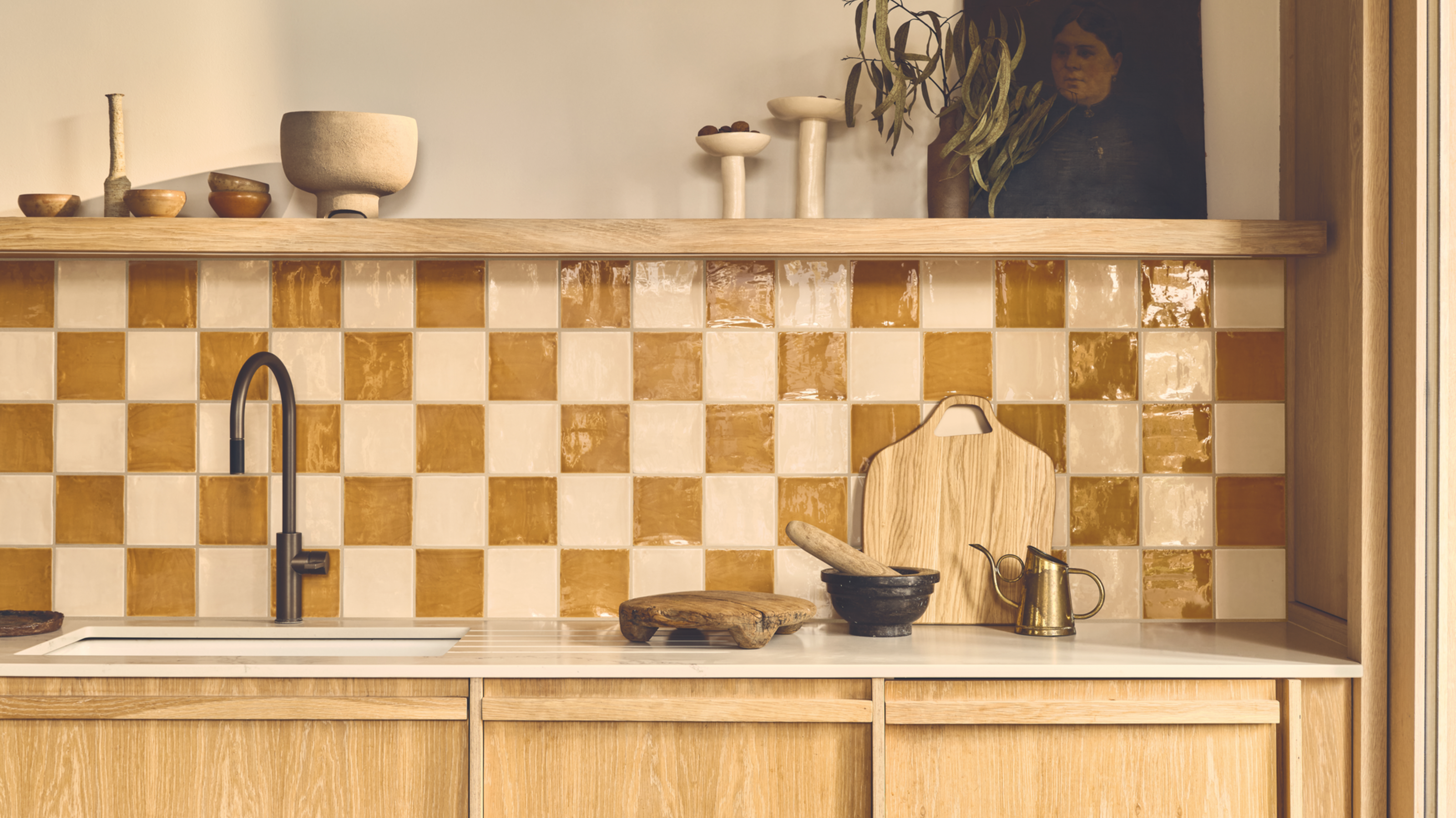 A kitchen with wooden cabinets, open shelving, and an orange and white checkerboard tiled backsplash