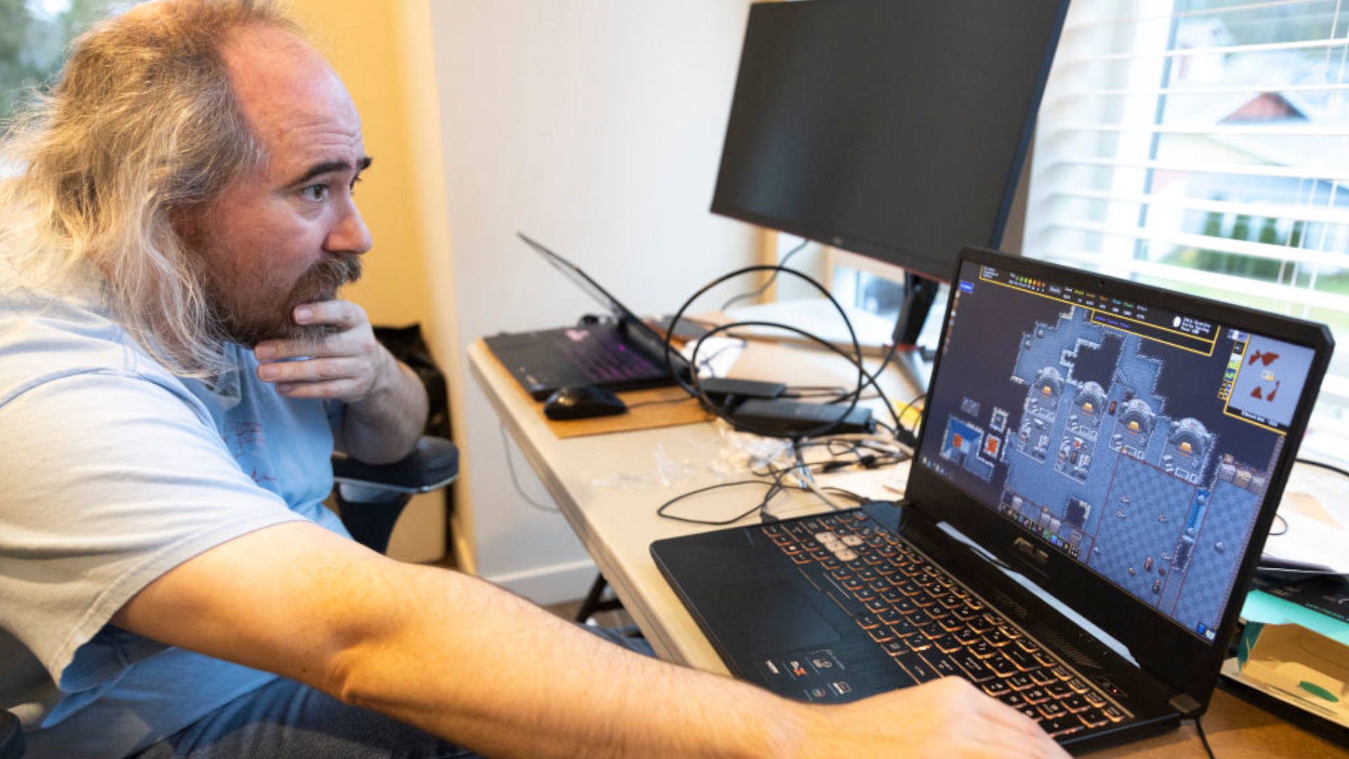 Tarn Adams, who cofounded Bay 12 Games with his brother Zach, talks about their single-player simulation game &quot;Dwarf Fortress&quot; during an interview at their home office in Poulsbo, Washington, west of Seattle, on December 9, 2022. - A cult favorite among indie game fans, &quot;Dwarf Fortress&quot; has been available for purchase on the Steam online store since December 6, a first for this title that has been distributed for free since its debut in 2006. The real-time management game, set in a medieval-fantasy world and involving overseeing a group of dwarves seeking to build a mighty fortress, has climbed to the fourth best-selling weekly title on Steam. (Photo by Jason Redmond / AFP) (Photo by JASON REDMOND/AFP via Getty Images)