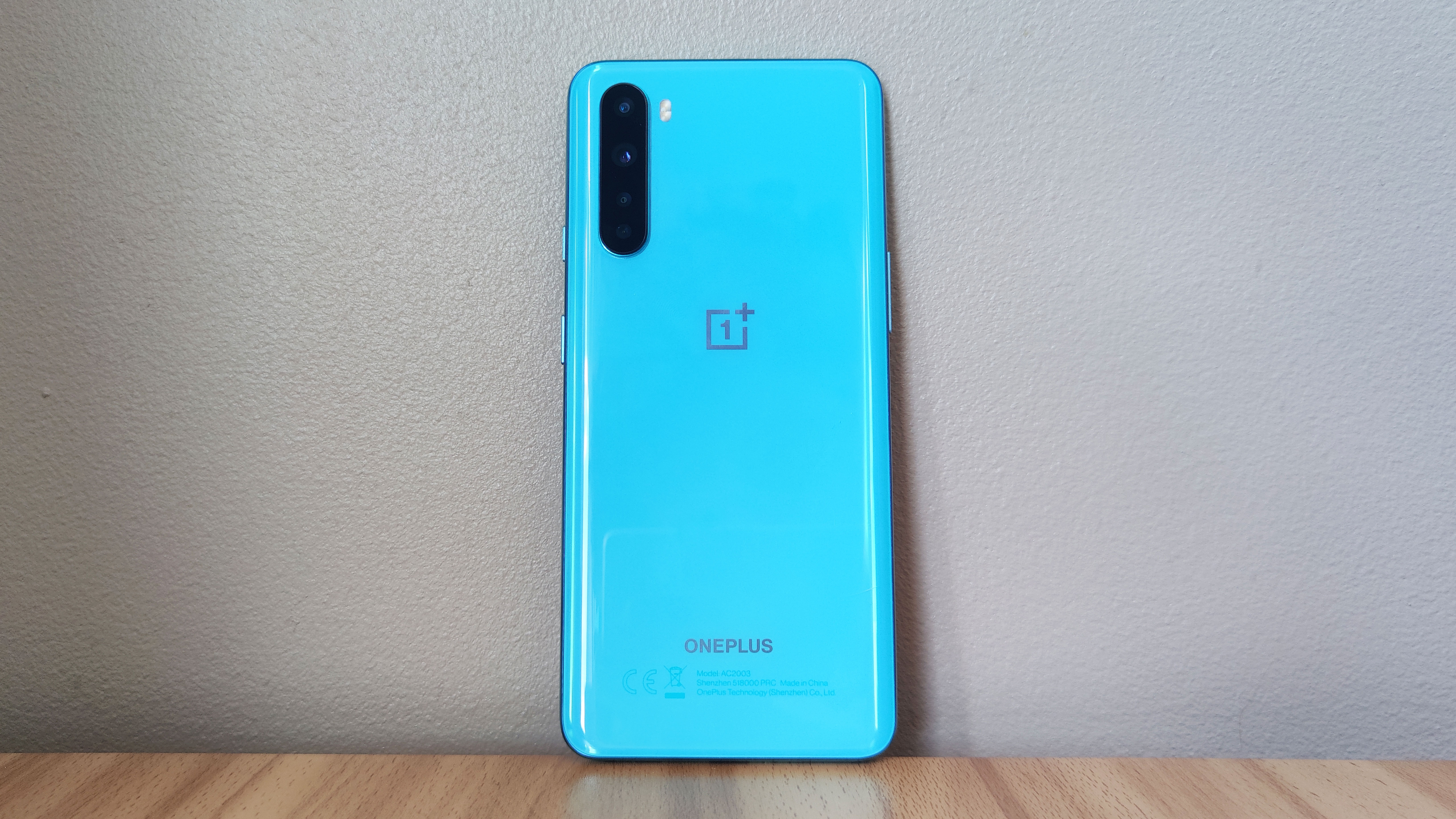 A OnePlus Nord in blue, resting against a wall