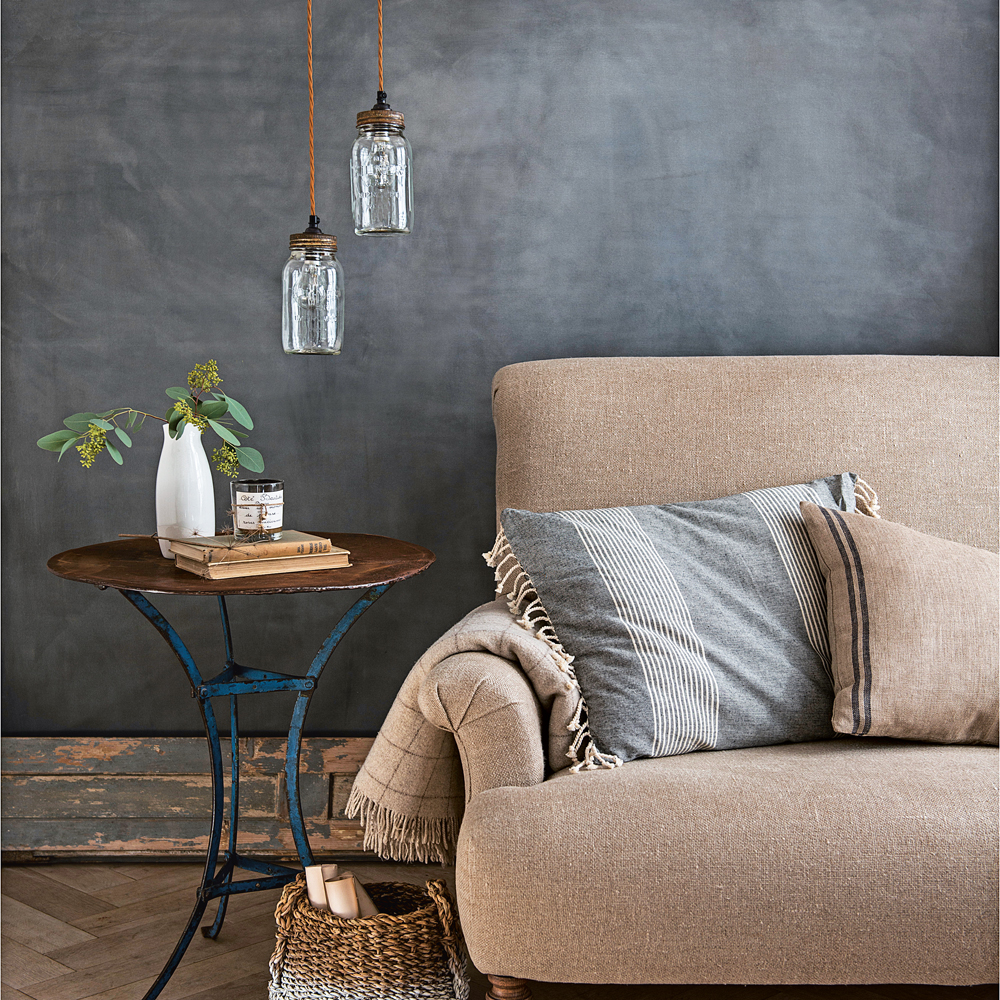 A natural cotton linen sofa with charcoal walls and jars for lights