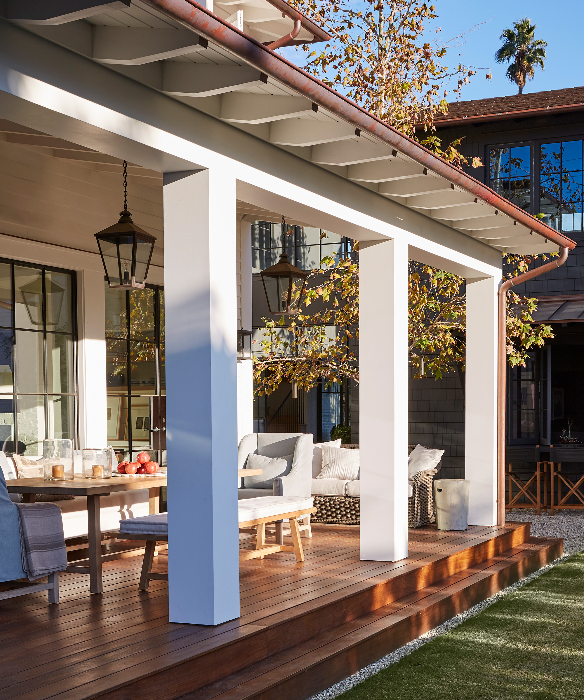 Front porch ideas for dining showing a wooden table on a wooden deck in the sun