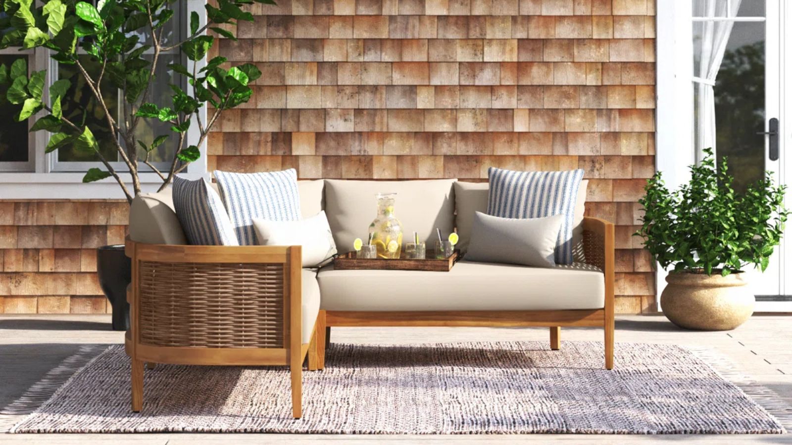 Wayfair corner wooden sofa on a patio with an outdoor rug and plants