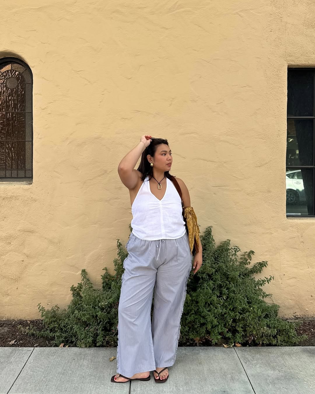 woman wearing square-toe flip flops with linen pants