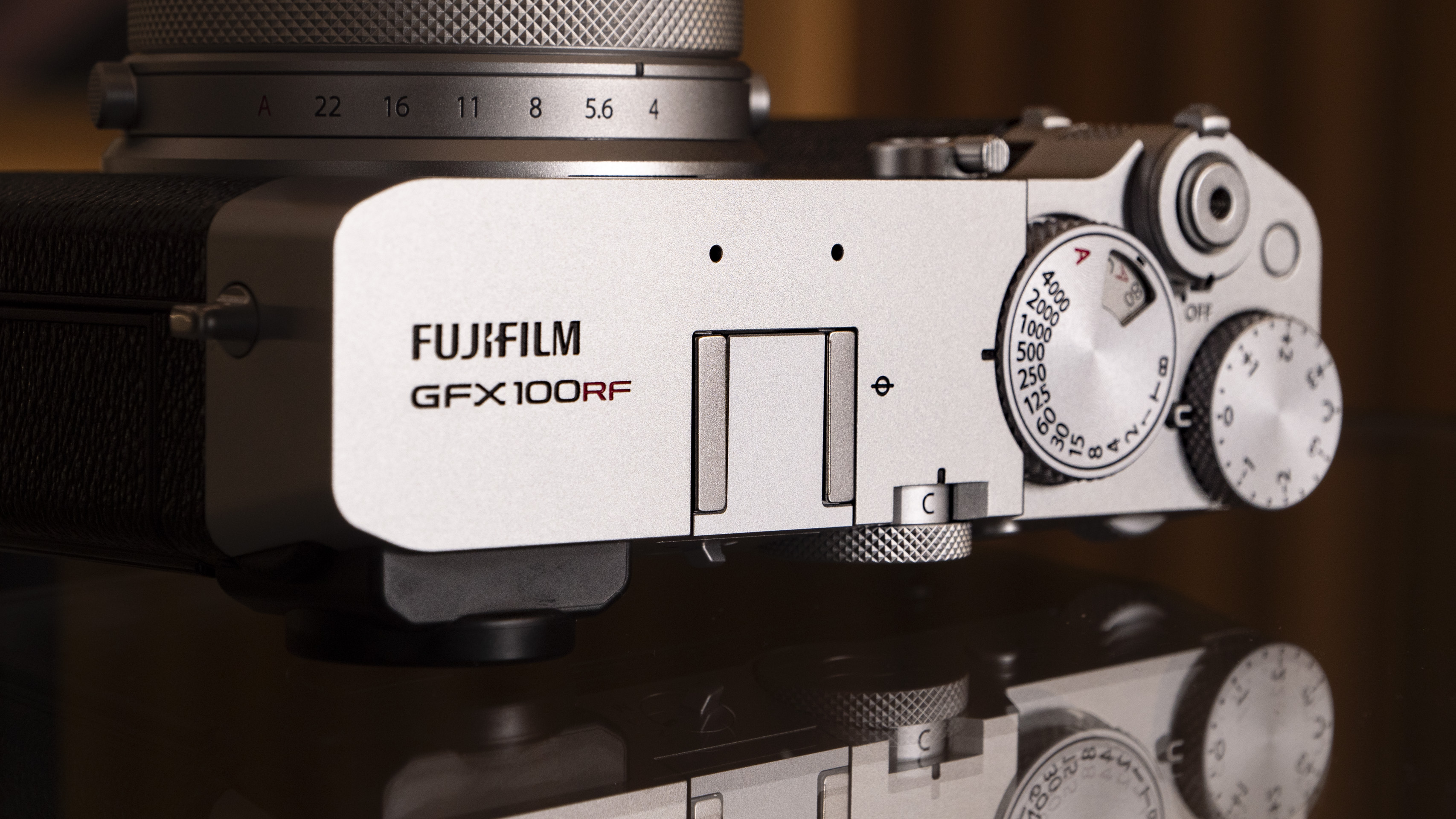 Fujifilm GFX100 RF medium-format compact camera on a glass table, top plate