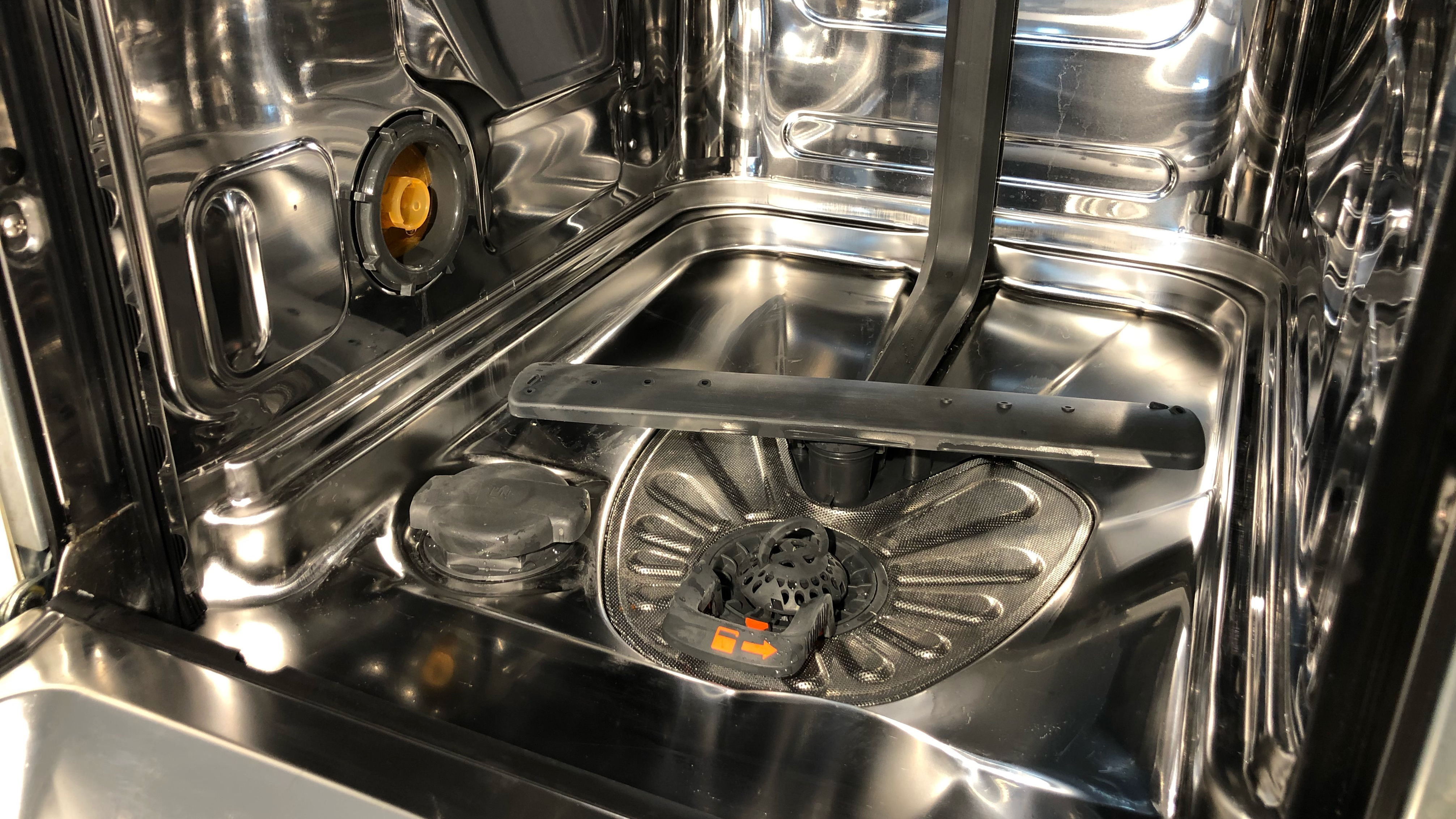 The inside of a clean dishwasher, with the racks and tracks removed