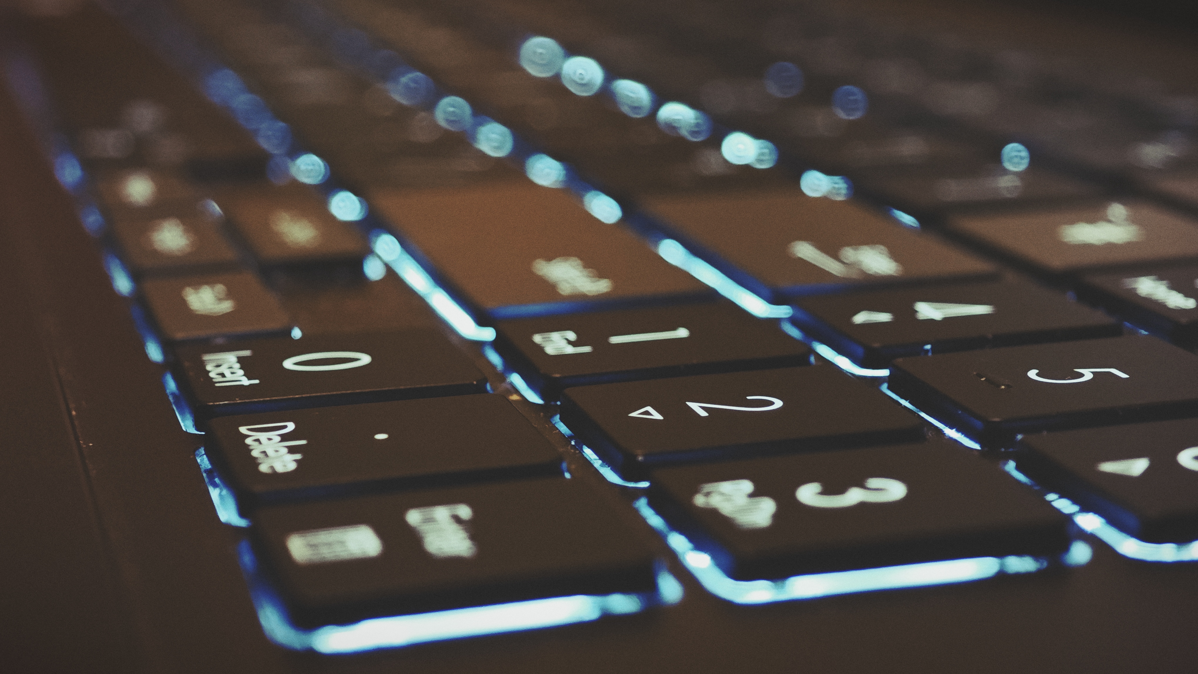 An Early Grey ASUS Vivobook Pro 15 OLED (2024) sitting on a wooden floor