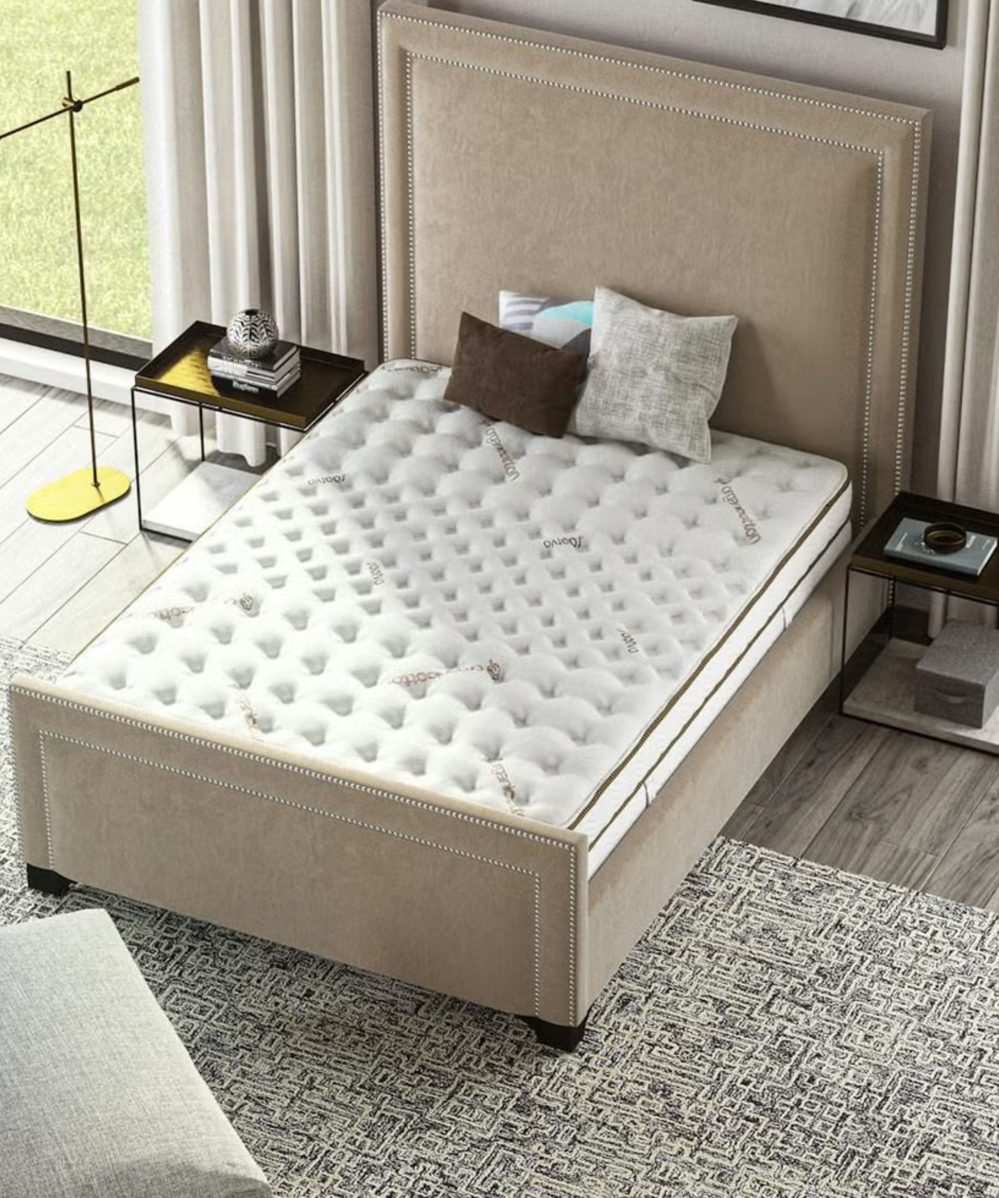 Bird&#039;s eye view of Saatva Latex Hybrid on a beige bed frame on a gray carpet with a dark wood nightstand either side. 