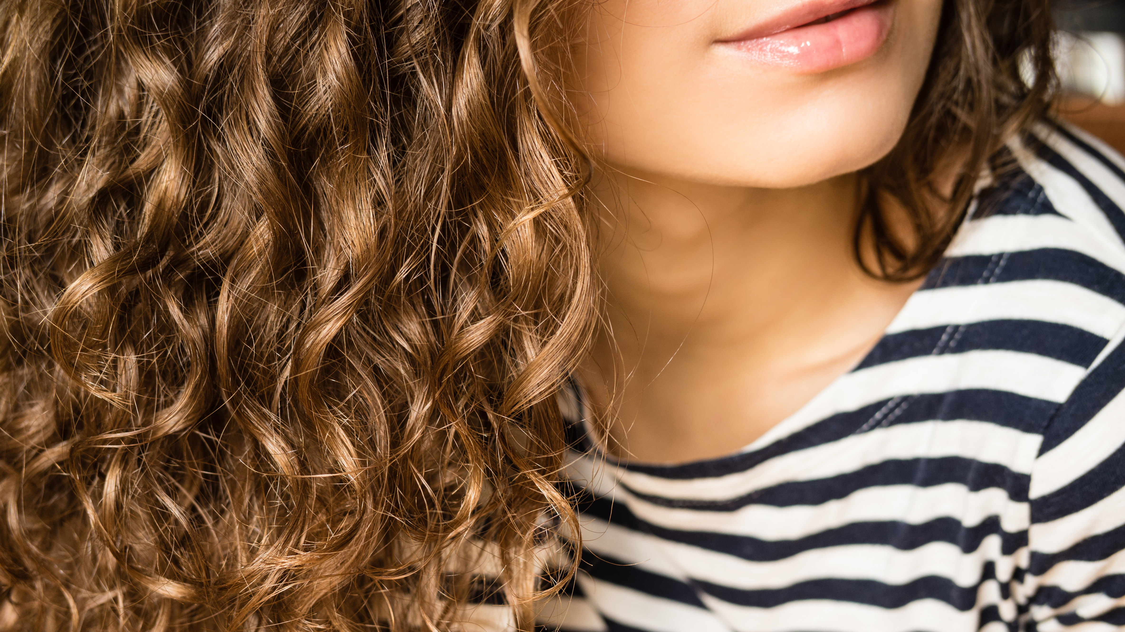 A woman with brunette curly hair