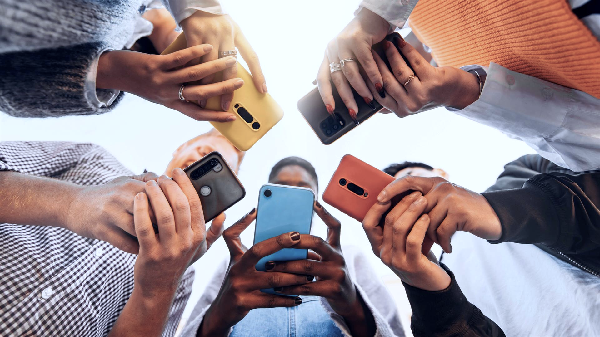 People gathering around while using smartphones