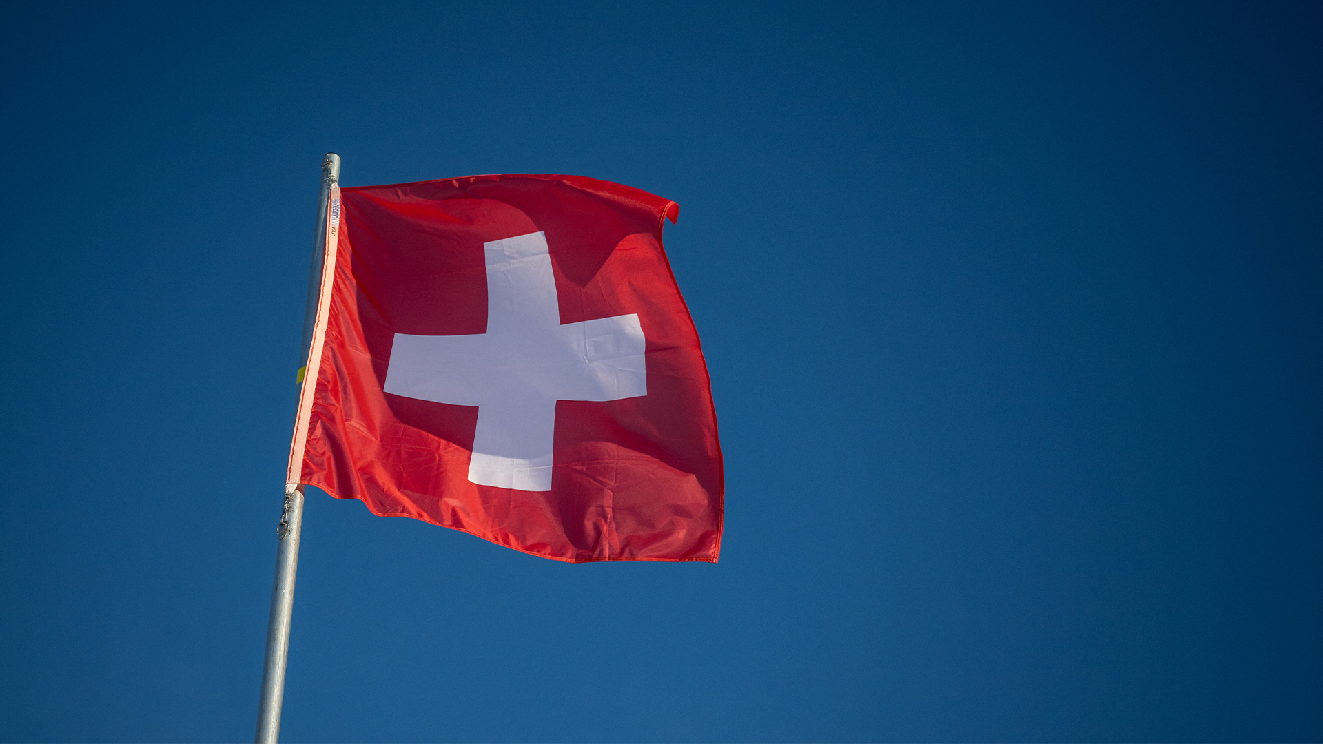 Swiss flag waving in a blue sky in St.Moritz on December 21, 2024