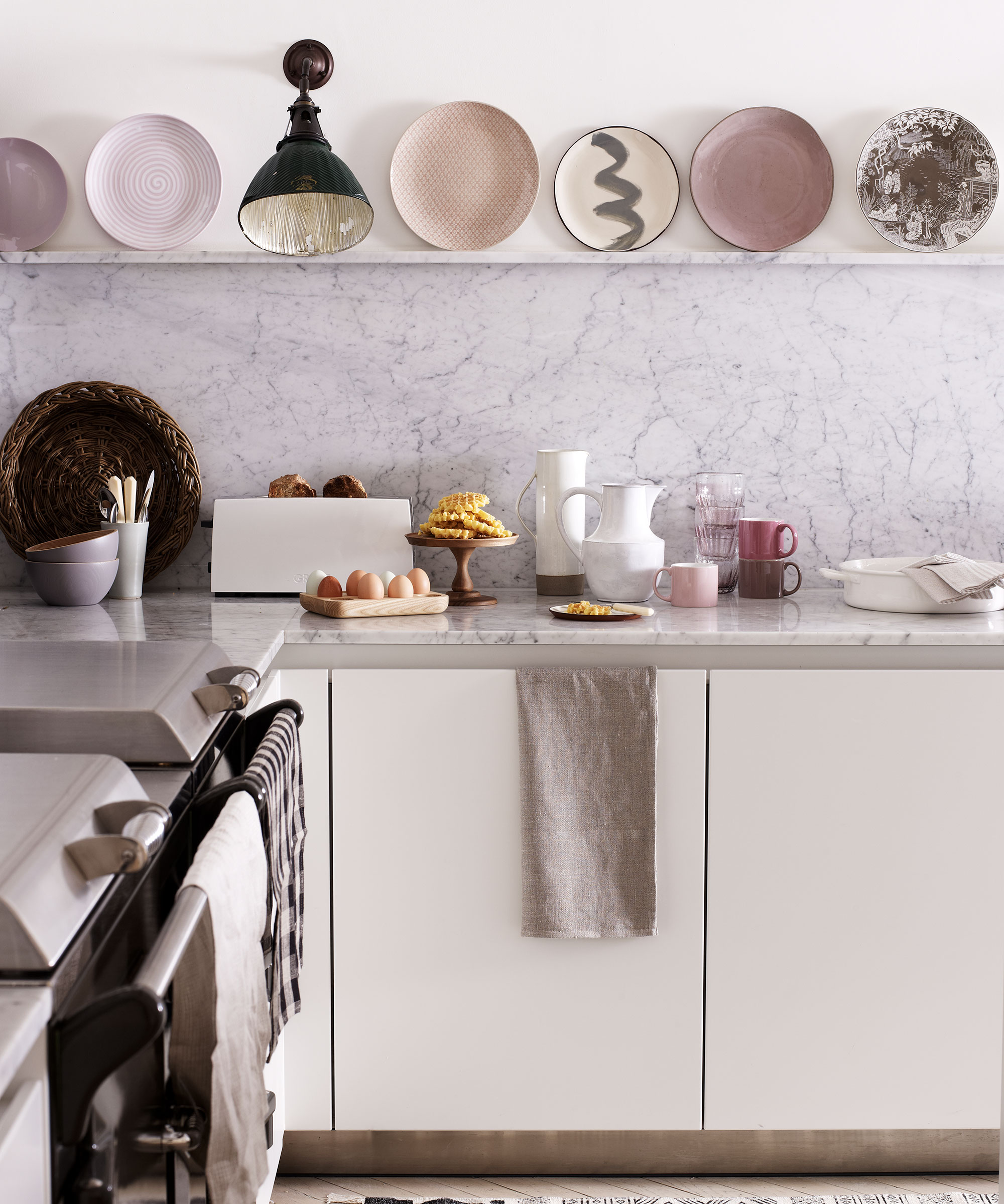 Kitchen wall lighting ideas with black wall downlight in a white kitchen with pastel pink accents.
