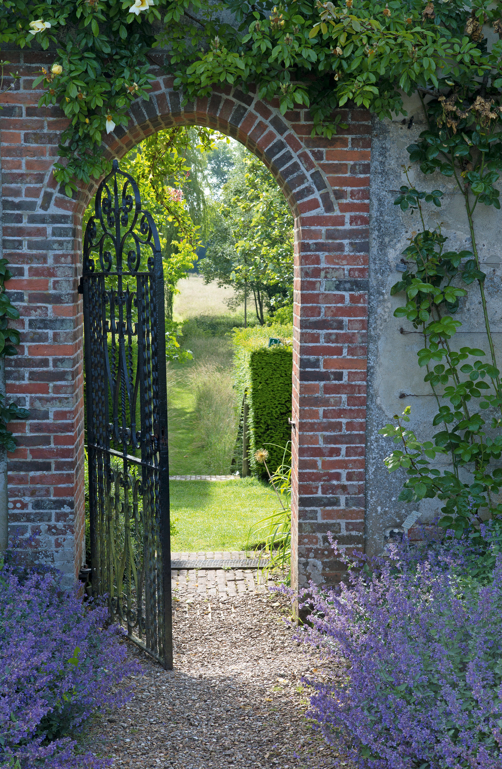 Metal gate in arched brick wall surround