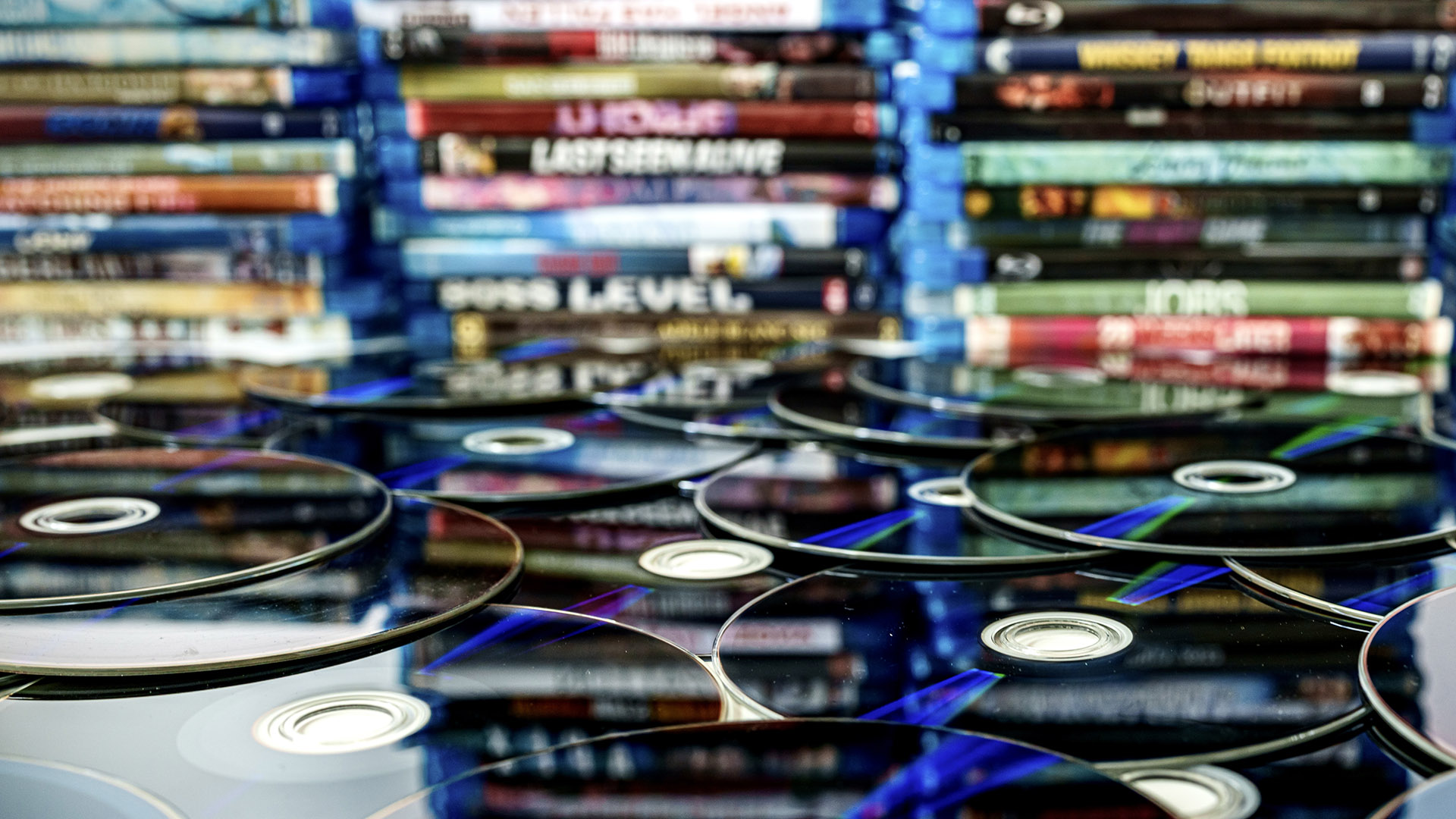 Series of Blu-ray discs with their cases in the background