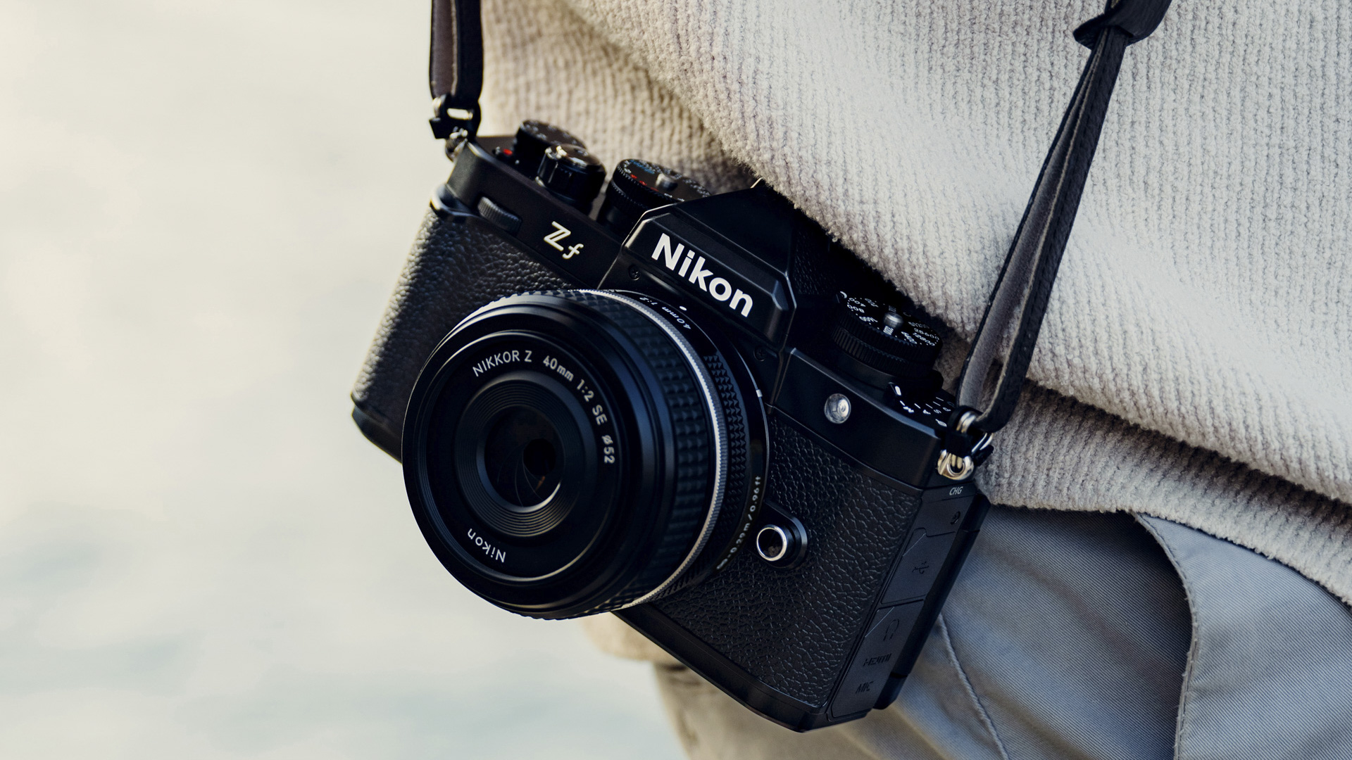Nikon Zf with Z 40mm F2 lens attached on a strap by photographer&#039;s waist