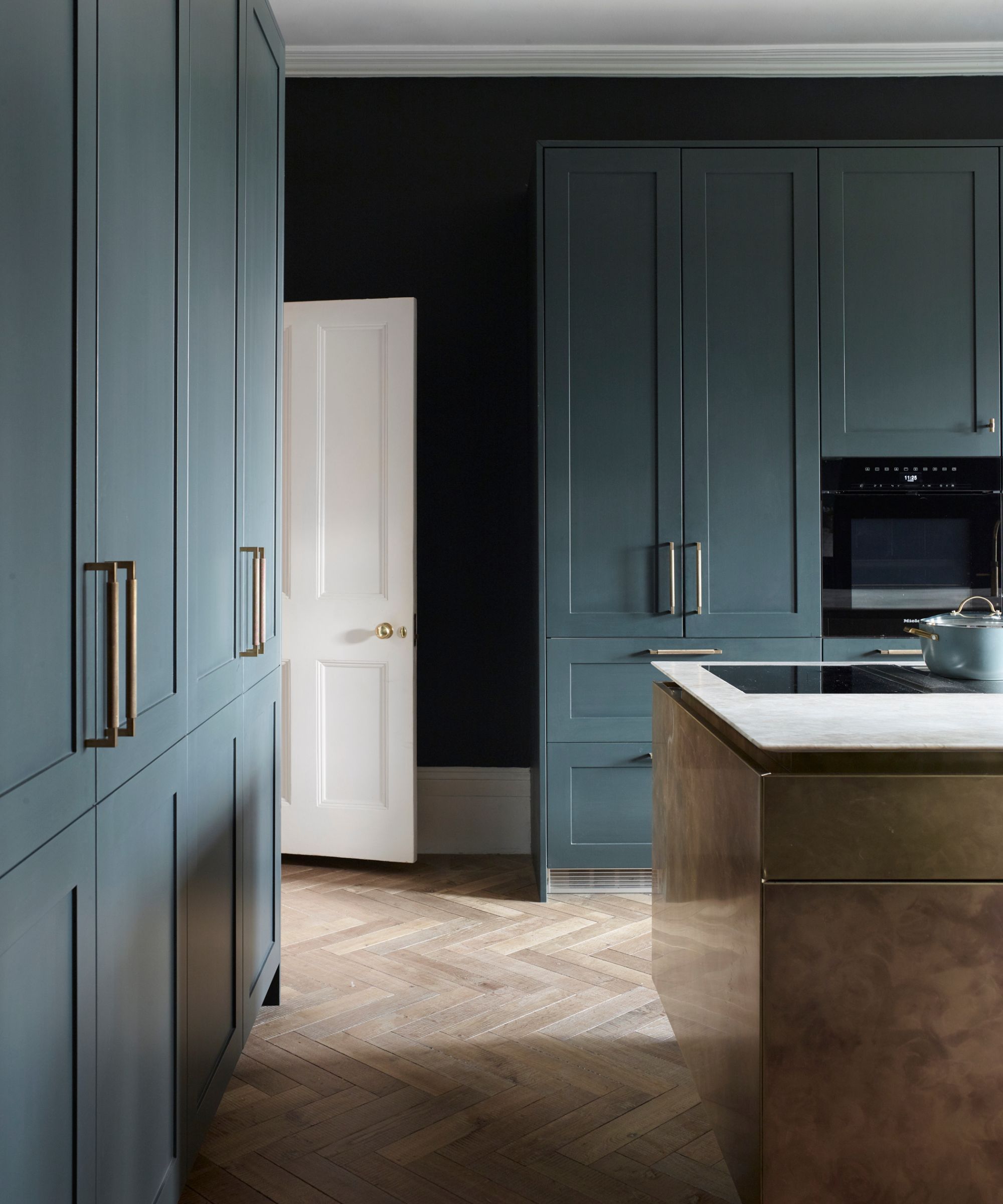 Black walls, blue cabinets, wooden floor