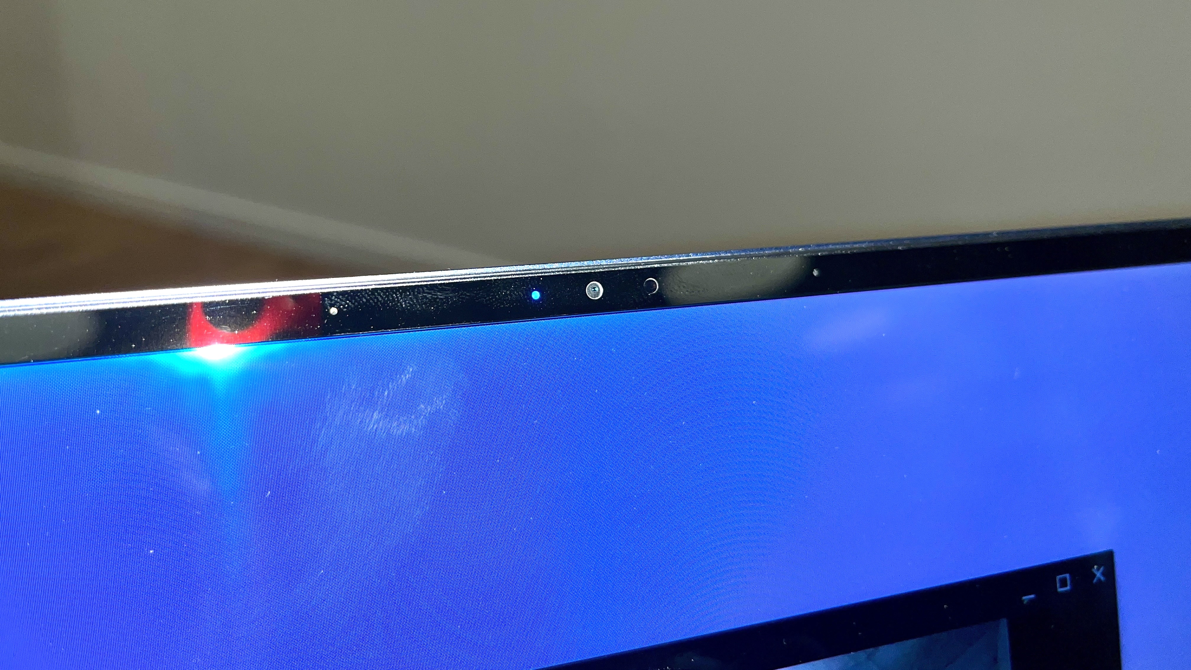 Close up of the webcam on the Samsung Galaxy Chromebook Plus, against a white wall.