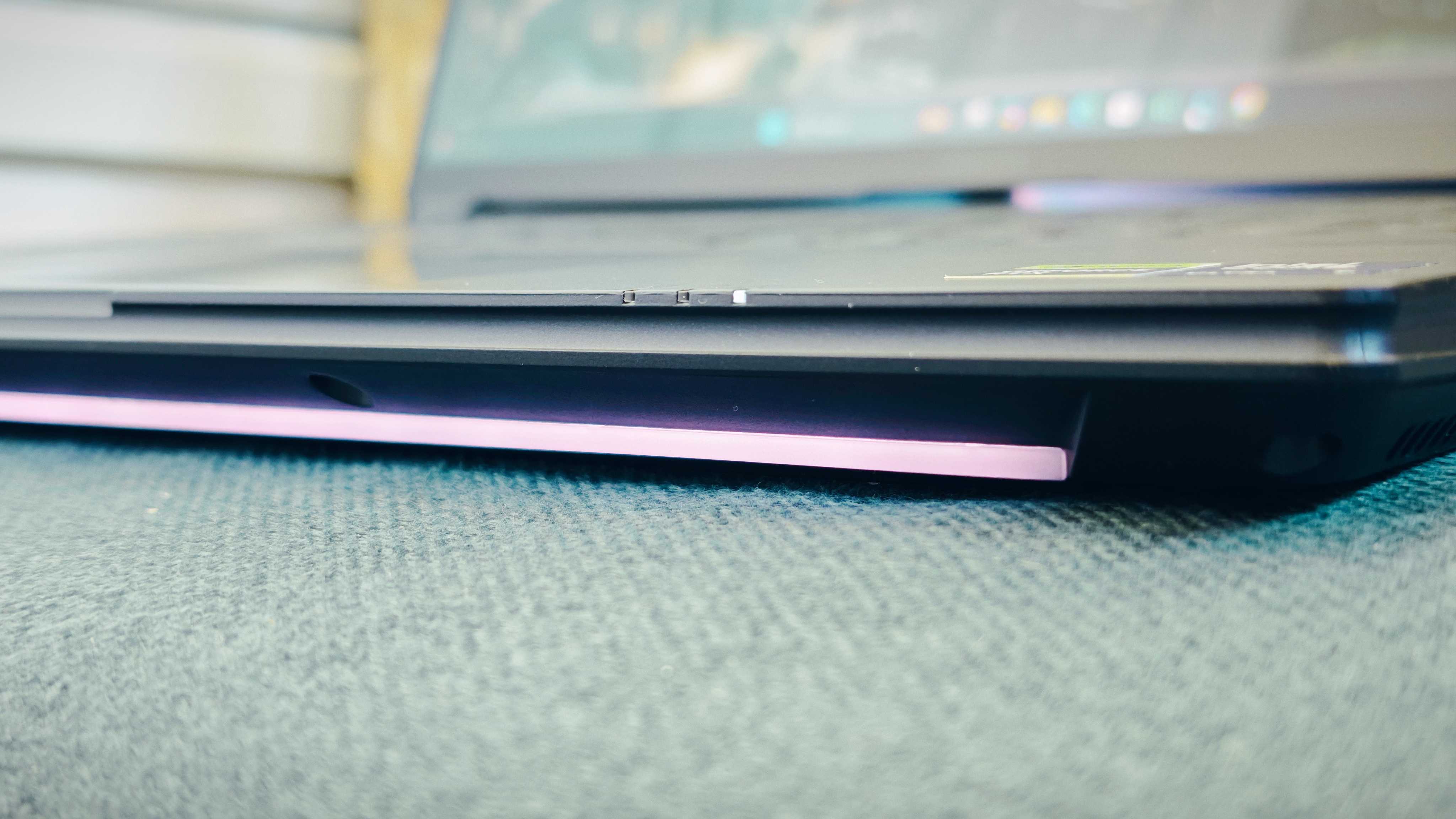 A Gigabyte Aorus Master 16 laptop on a green sofa