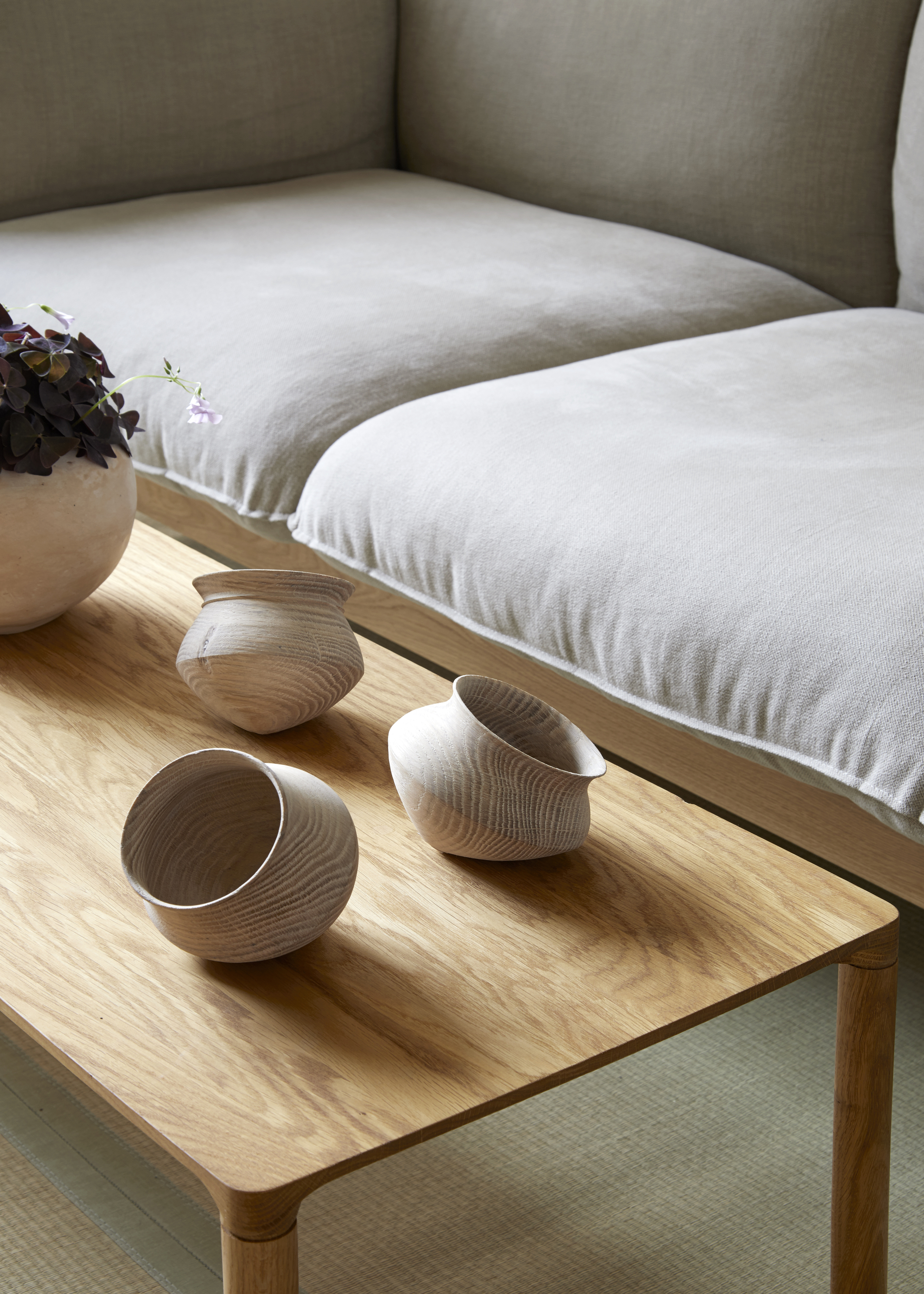 A wooden coffee table with decorative wooden planters arranged on the tabletop