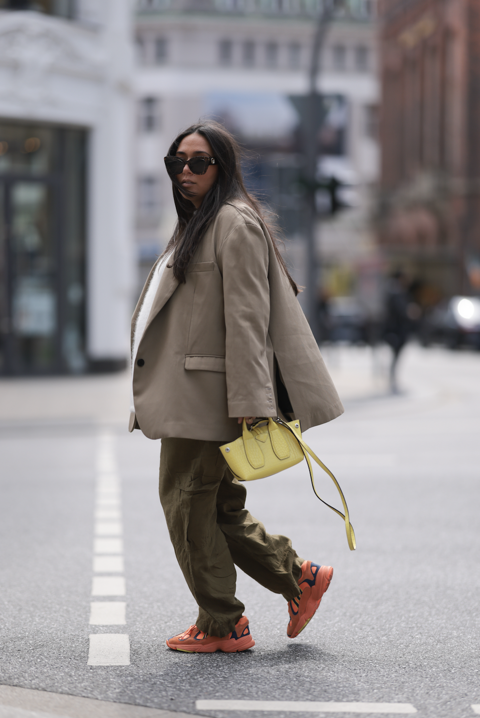 Jennifer Casimiro seen wearing Zara olive beige linen pants, by Aylin Koenig white shirt, the Frankie Shop beige brown blazer, Adidas orange sneaker, yellow Longchamp bag, Fendi shades on May 08, 2023 in Hamburg, Germany.