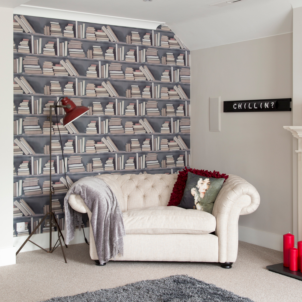 Living room with bookcase wallpaper and a white sofa