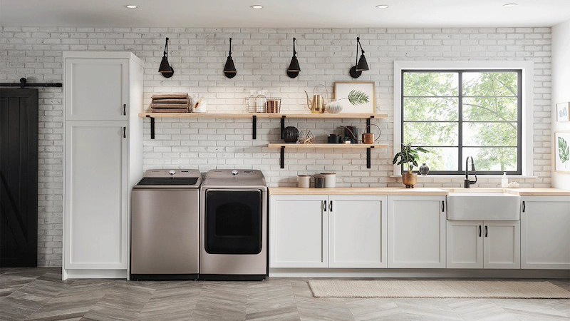 The Samsung 5.4 cu. ft. Top Load Washer with Super Speed in Champagne shown in a beautiful white, modern kitchen