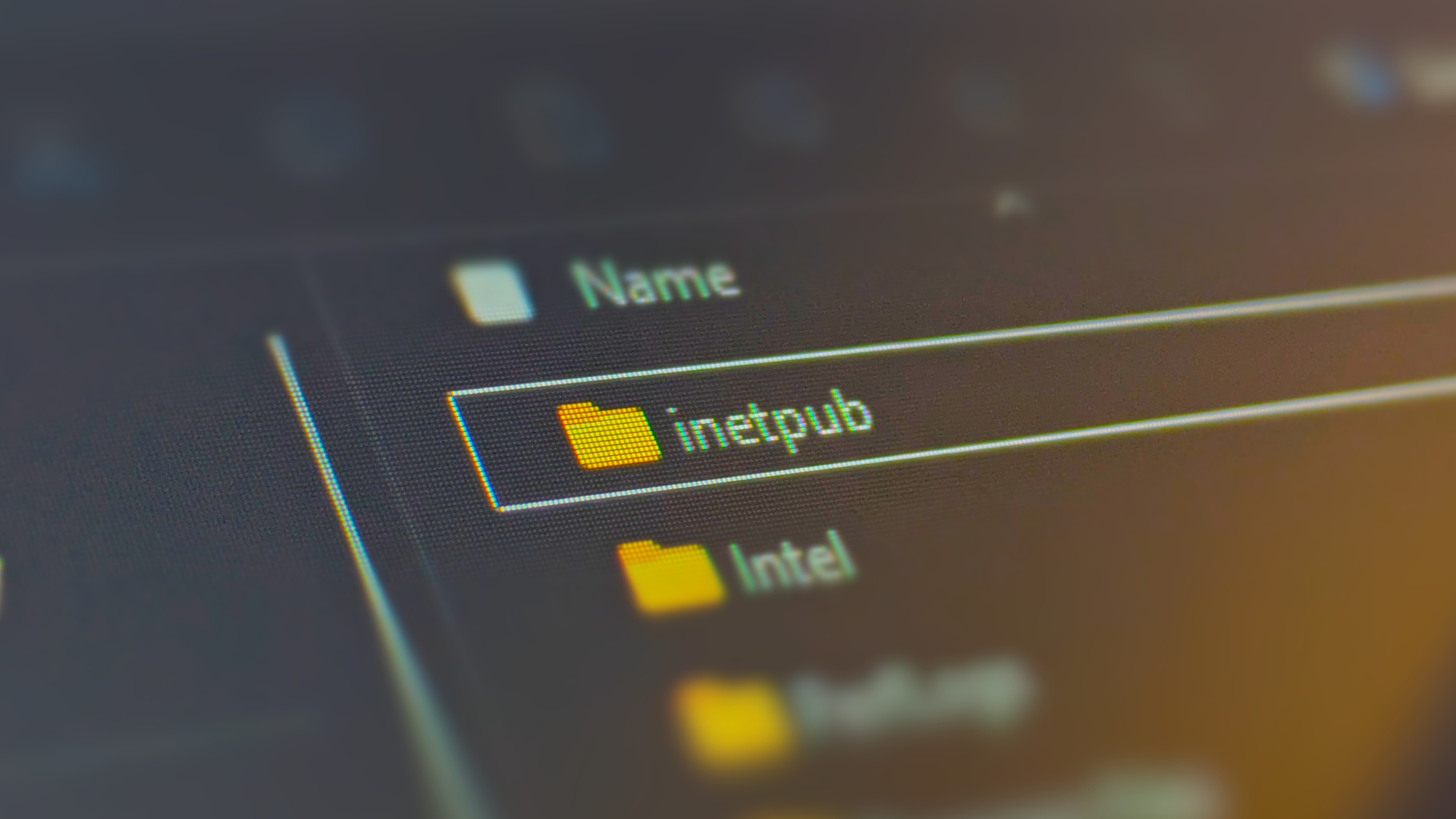 Photograph focusing on a laptop screen showing the &#039;inetpub&#039; folder in Windows 11&#039;s system drive.