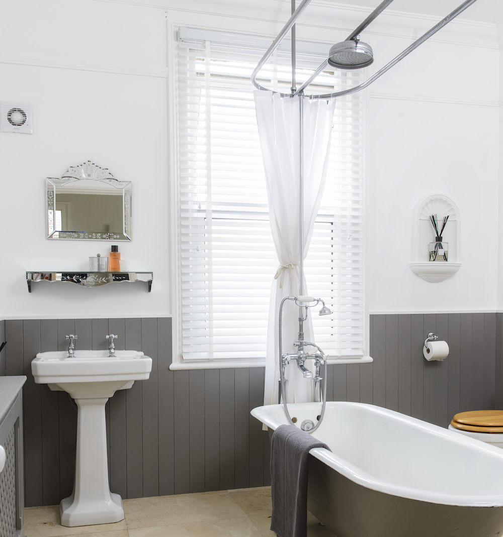 bathroom with white and grey wall bathtub and wash basin