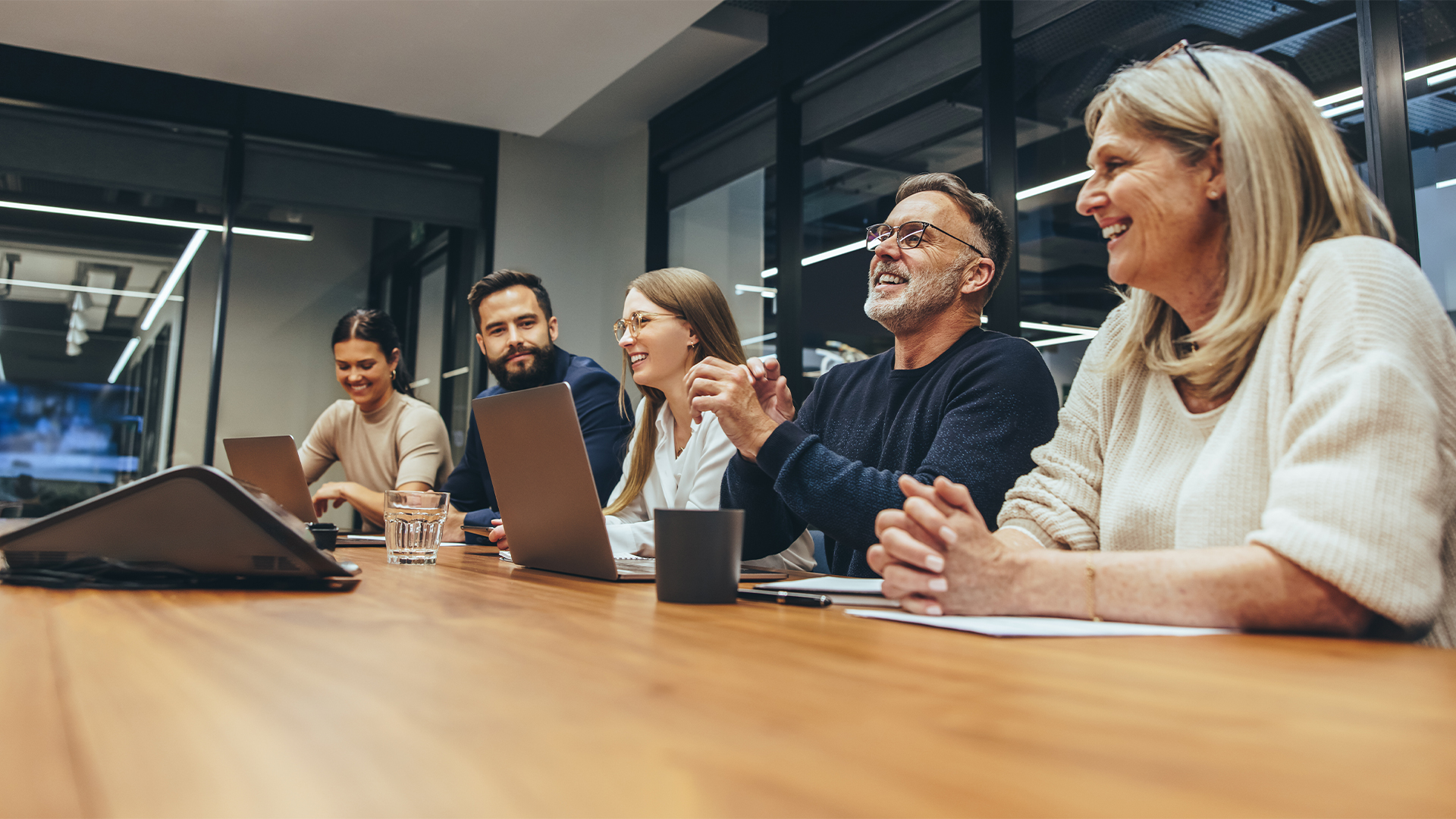 Diversity concept image showing business professionals of all ages in an office meeting room, with Generation X, millennials, and Gen Z all pictured.