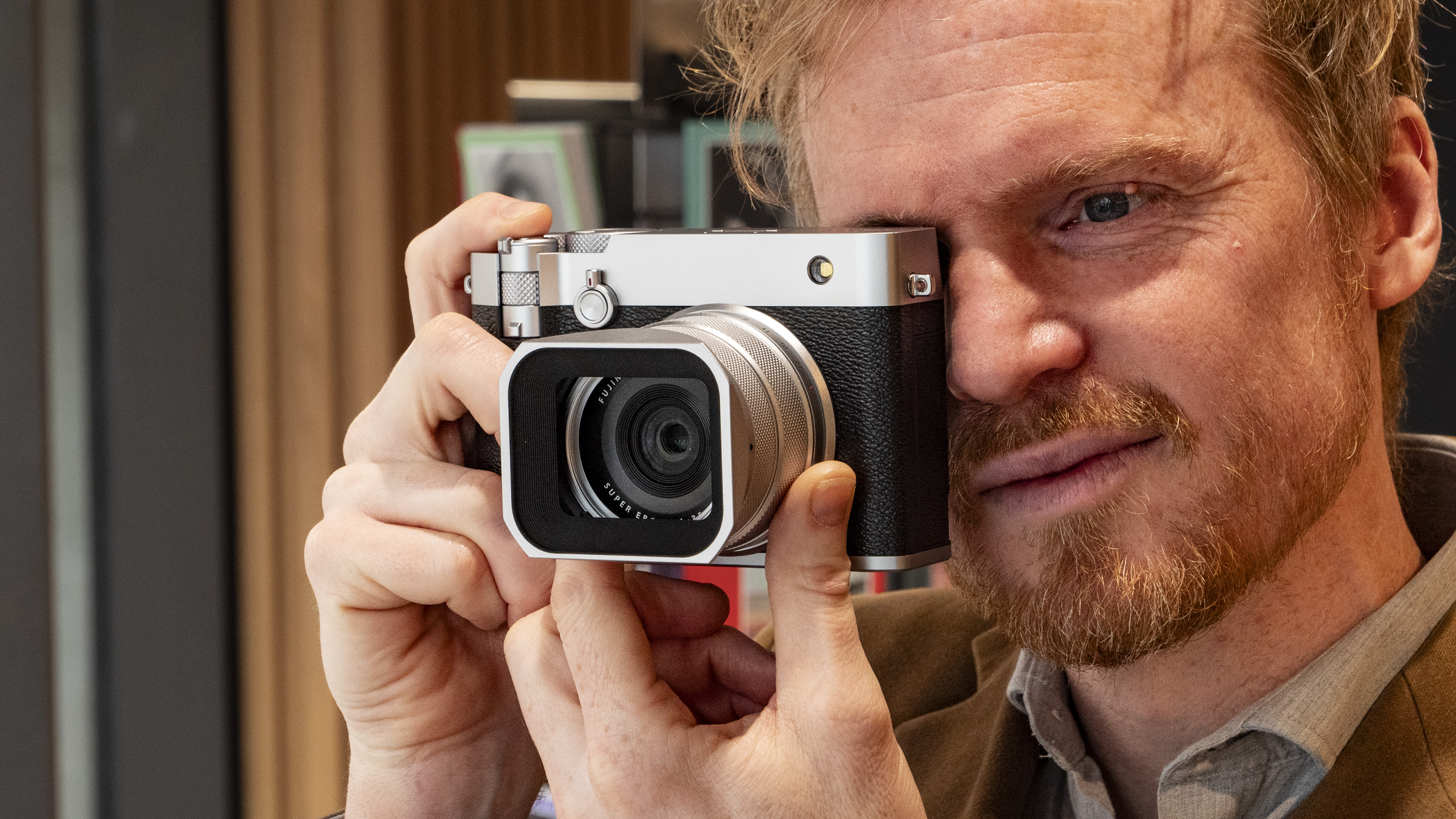 User holding the Fujifilm GFX100 RF medium-format compact camera up to their eye