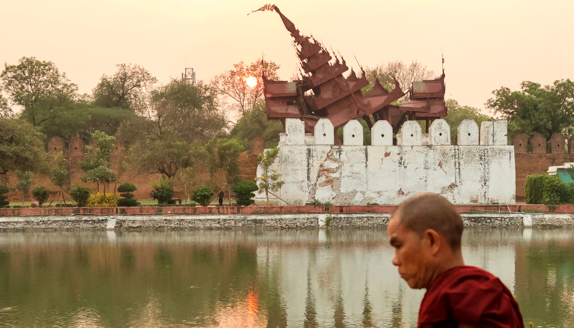 A Buddhist monk walks past the heavily damaged Mandalay Palace days after the 7.7-magnitude earthquake struck Myanmar