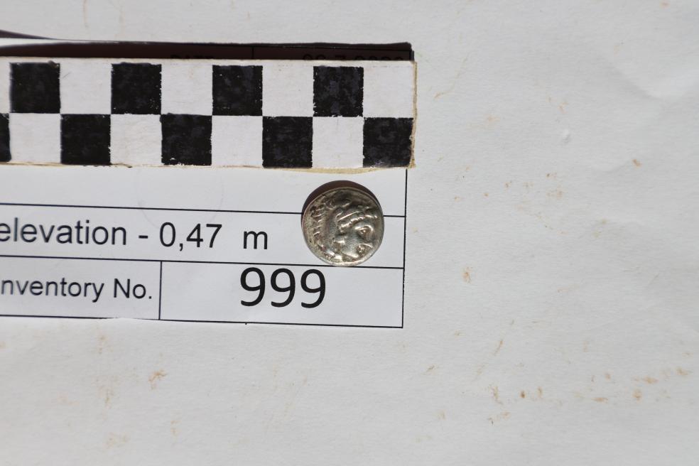 a close-up of a silver coin with a face