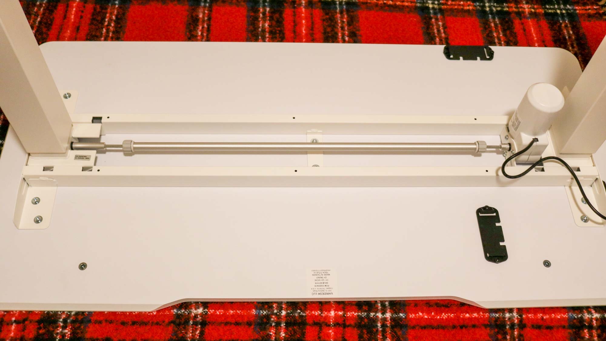 The underside of the Vari Essential Electric Standing Desk showing its single motor and rod system