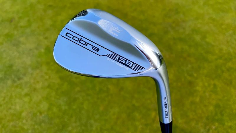 Cobra Snakebite 2023 Wedge being held aloft on the golf course