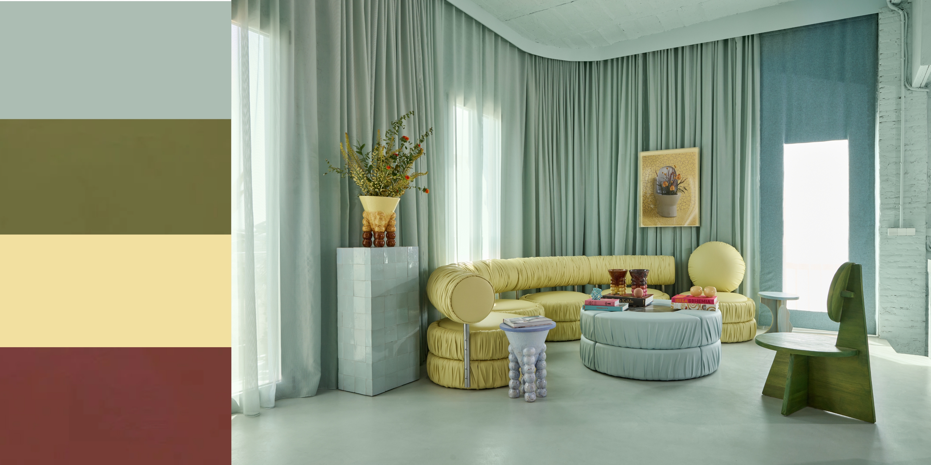 Image of an ice blue living room color-drenched in the shade. The floors, curtains, walls, ceiling, and furniture are all ice blue. There is a curved sofa in a pistachio green color, and little accents of lavender and oxblood are dotted around the room.