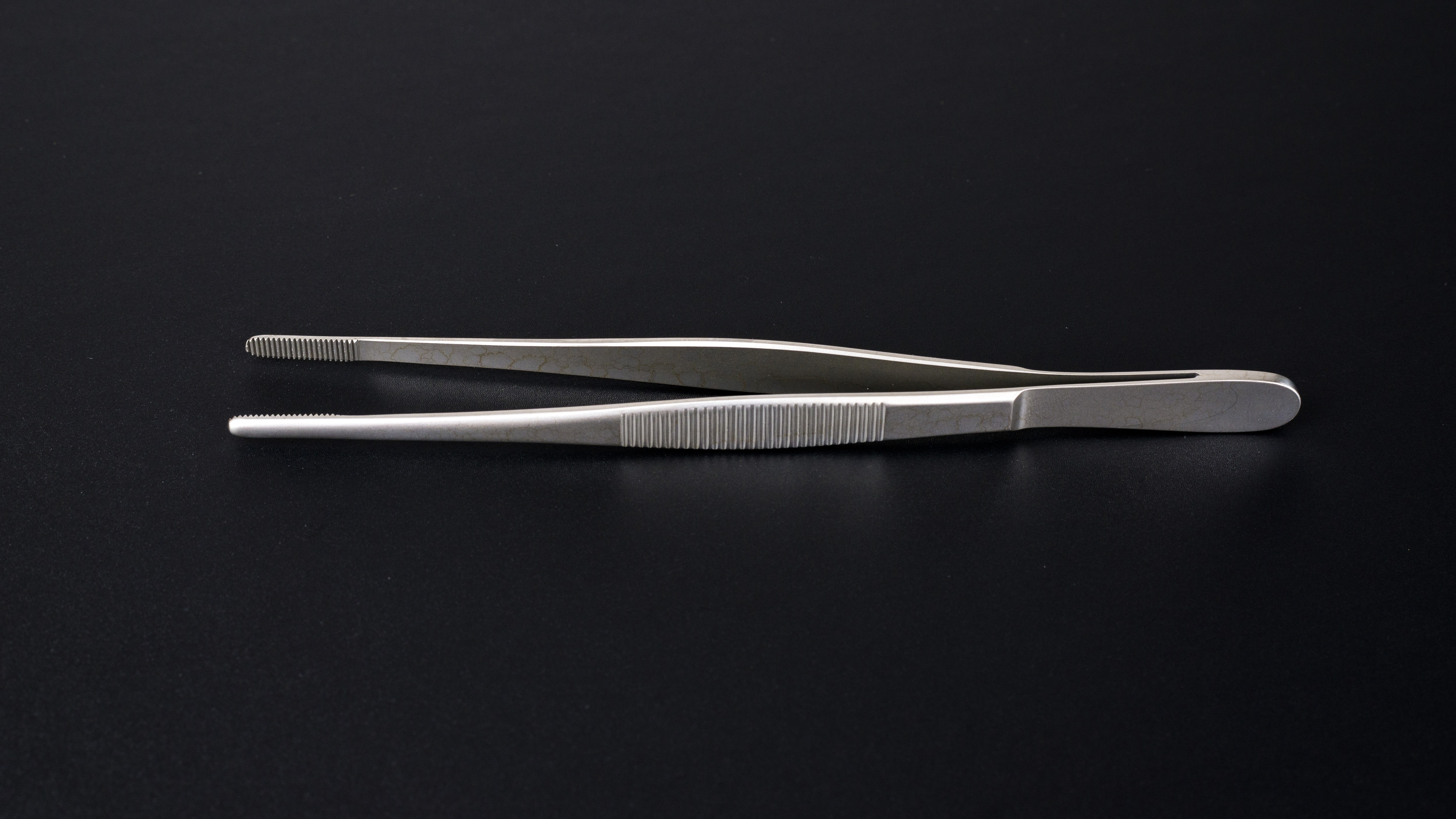 Tweezers on black background